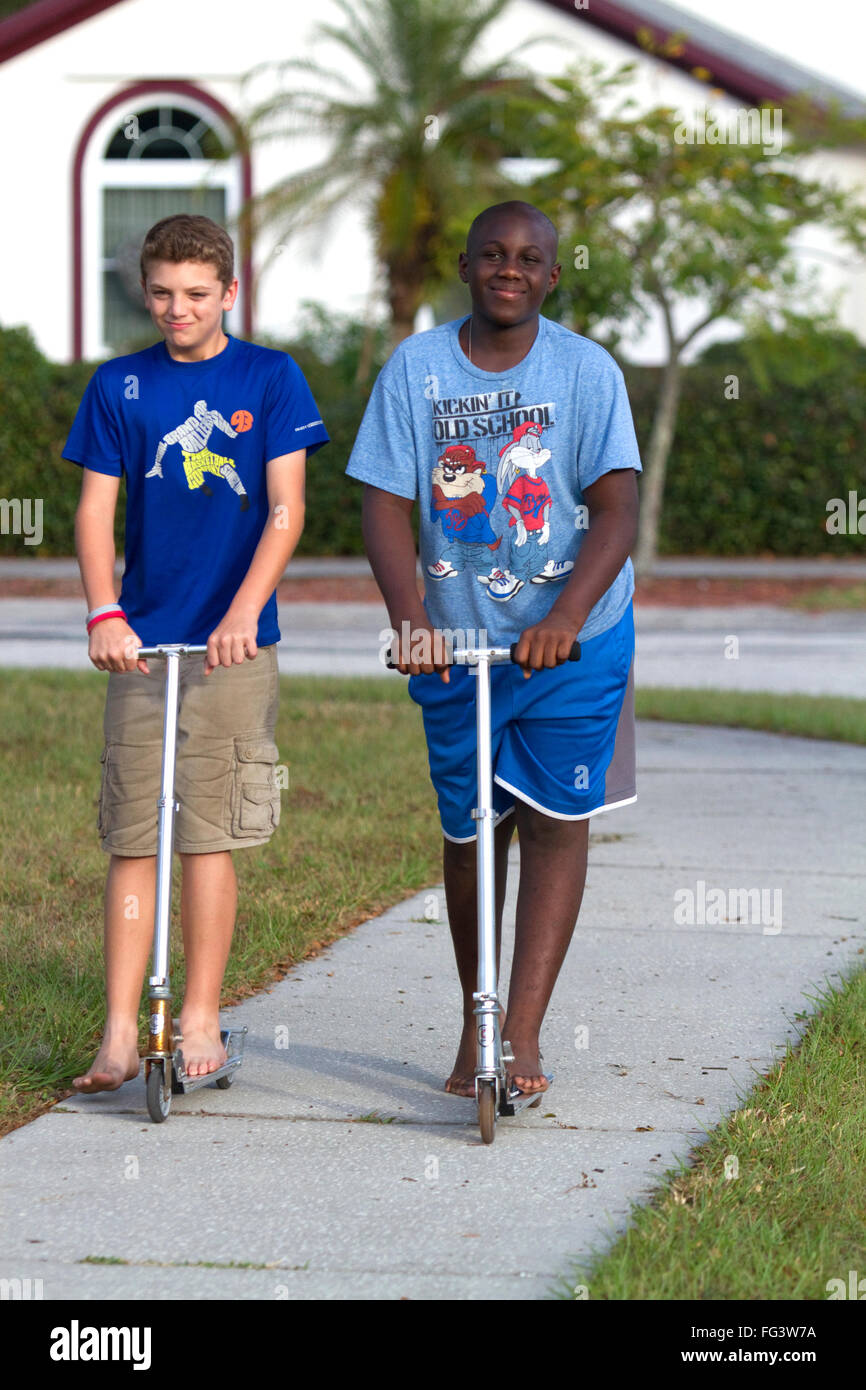 Two 11 year old boys riding scooters in Florida, USA. Stock Photo