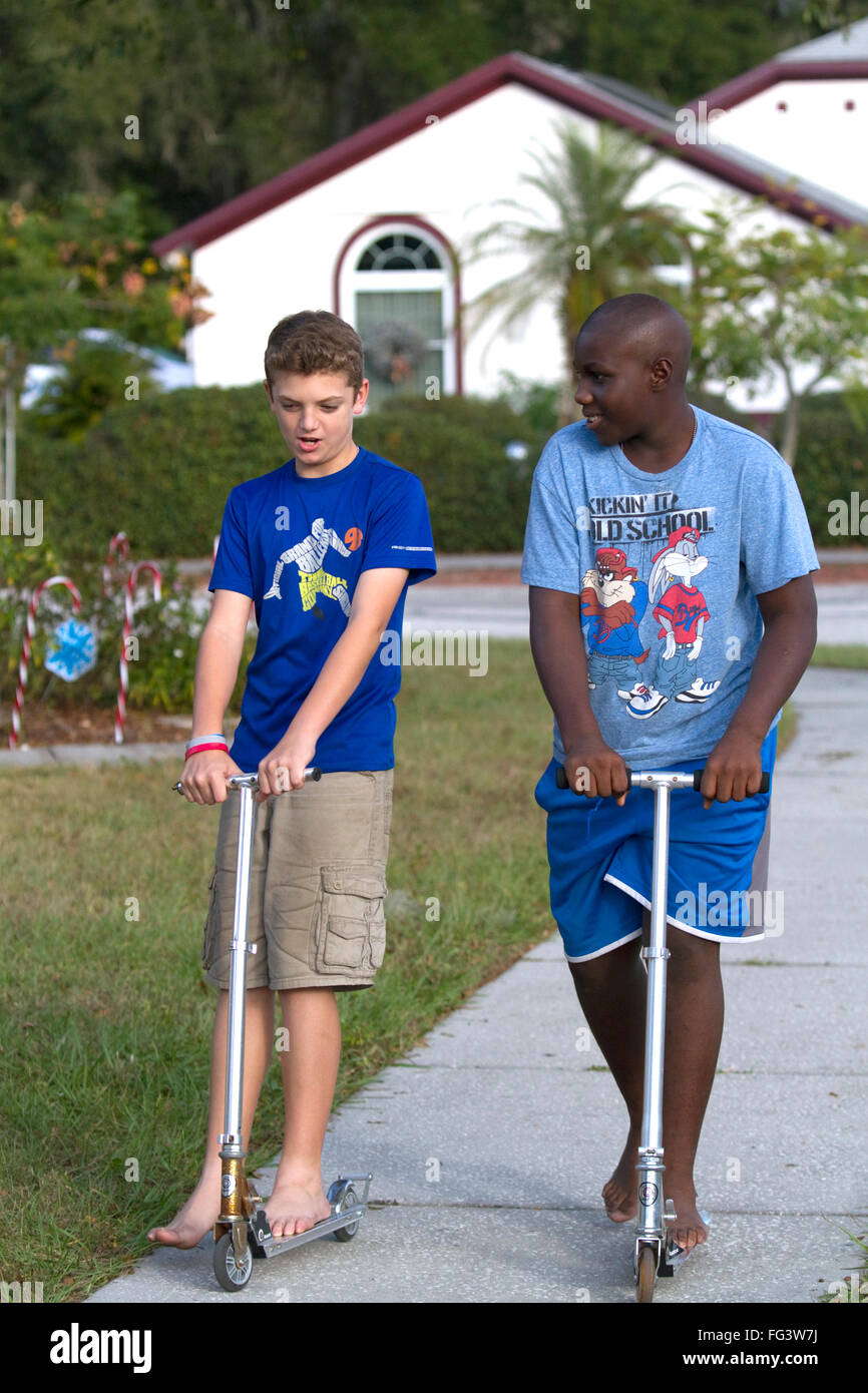 Two 11 year old boys riding scooters in Florida, USA. Stock Photo