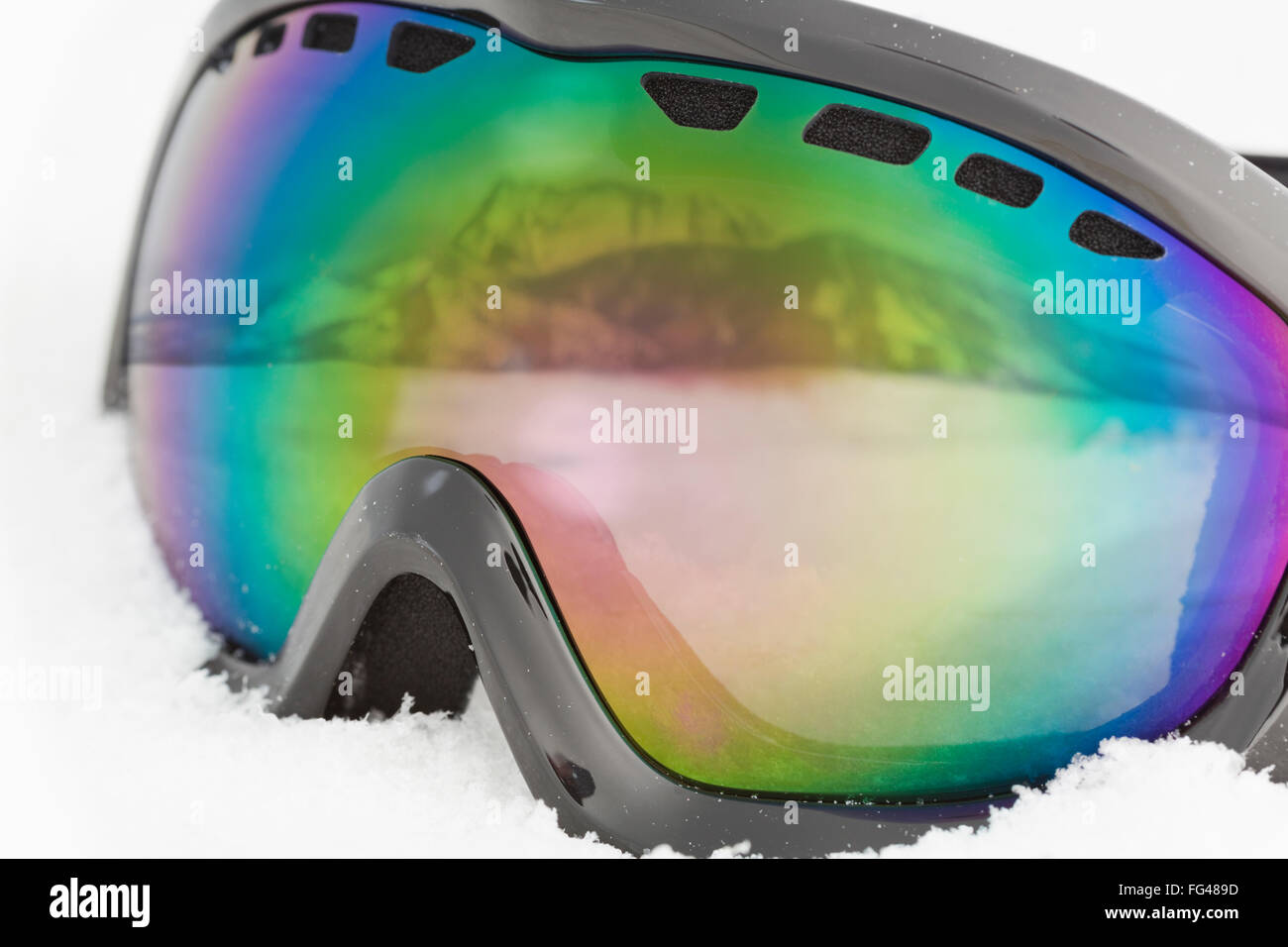 Goggles with mountain reflection in snow Stock Photo