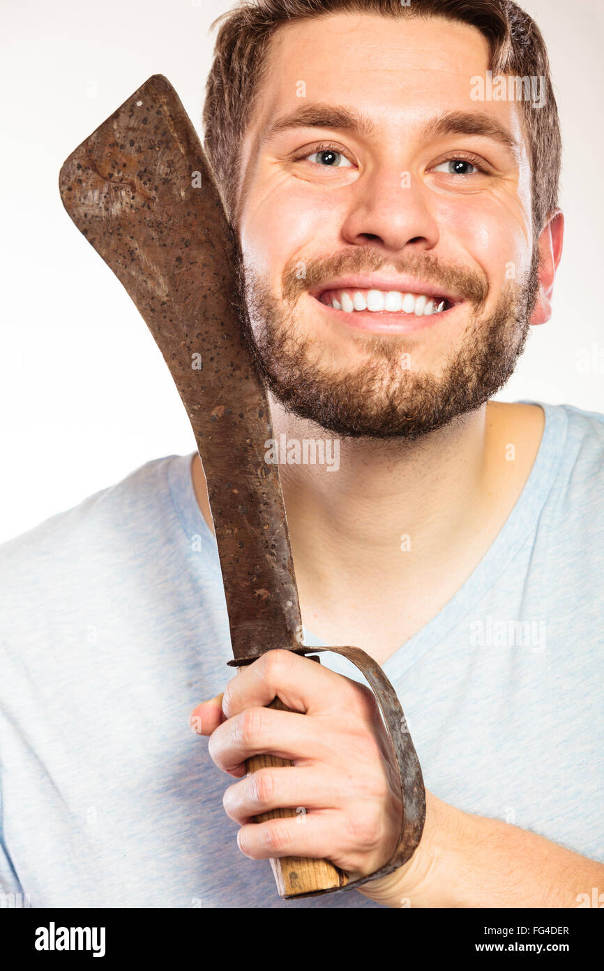Young man with shaving having fun with machete large knife. Handsome guy removing face beard hair. Skin care and hygiene humor. Stock Photo
