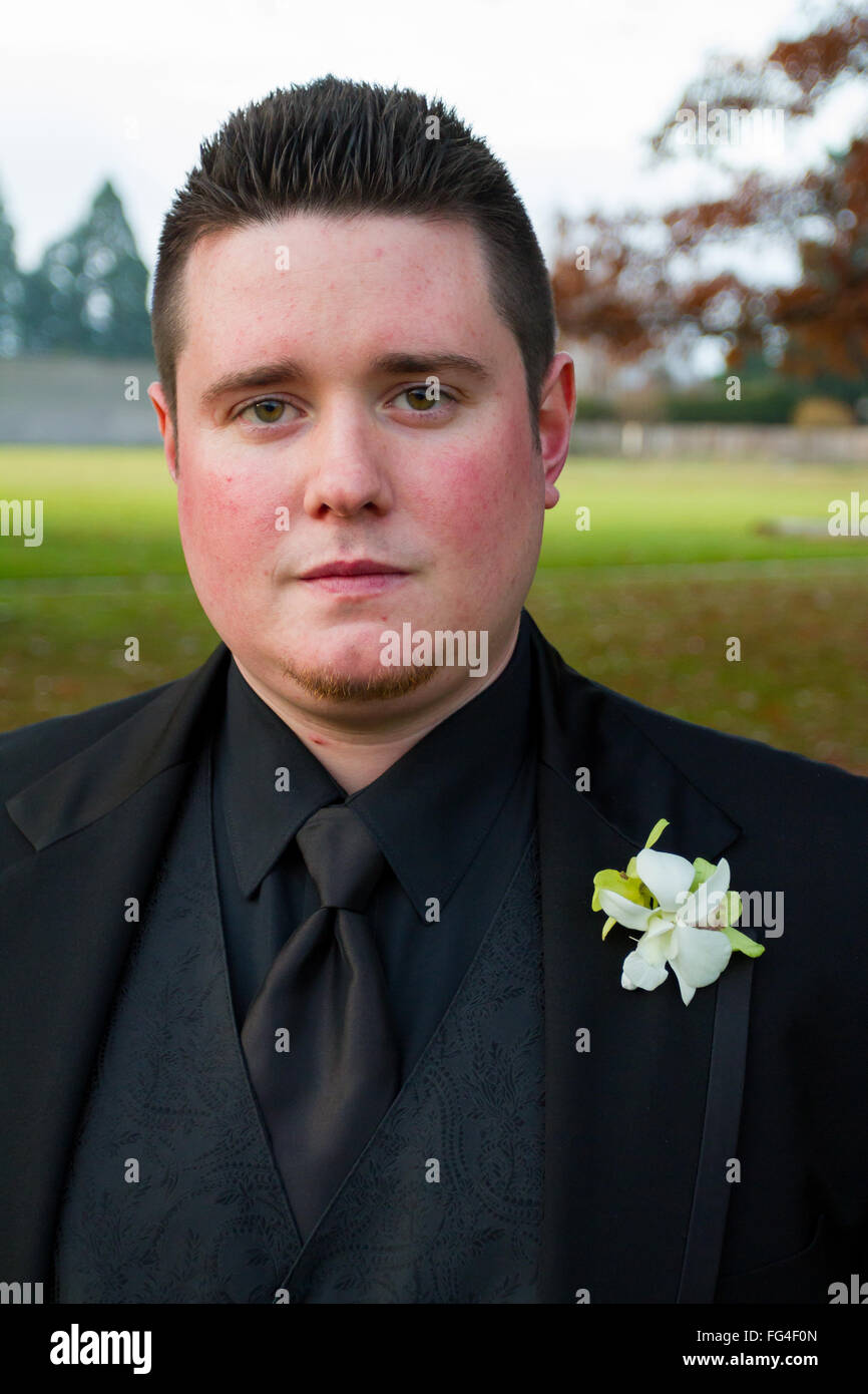Groom posing for a portrait outdoors on his wedding day in Oregon, wearing a black tux Stock
