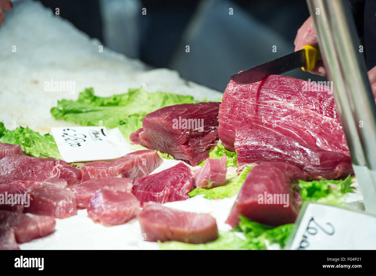 fisherman cuts a slice of red tuna with a knife Stock Photo