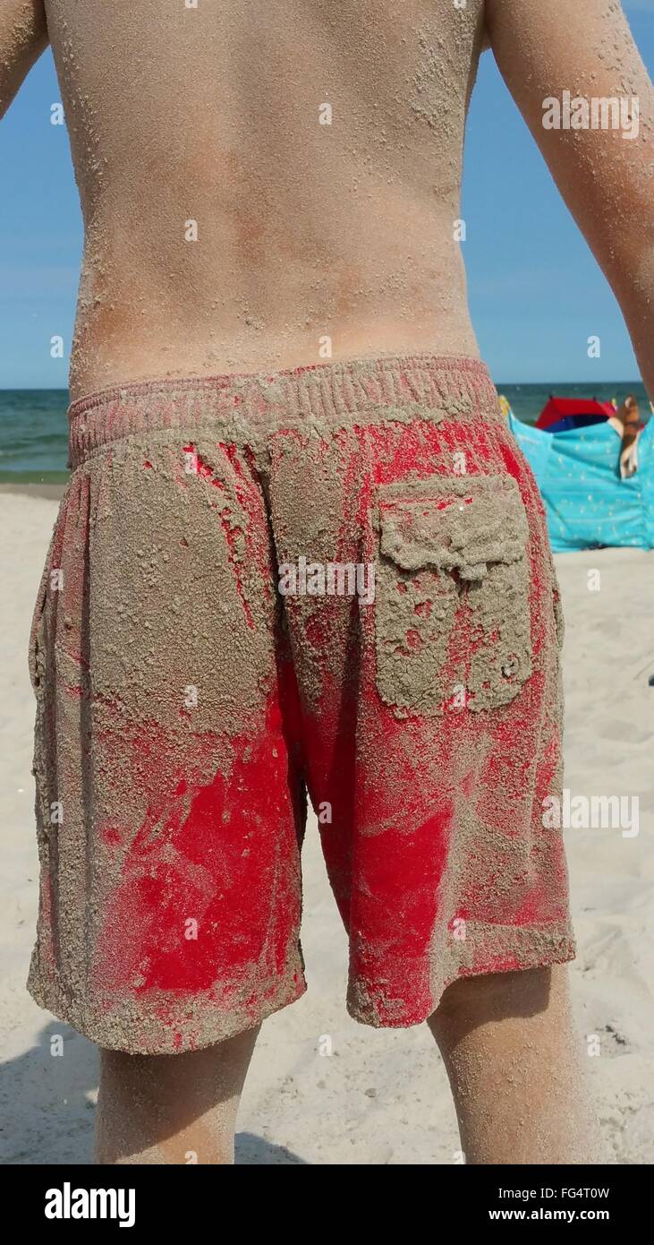 Man On Beach With Sandy Shorts Stock Photo