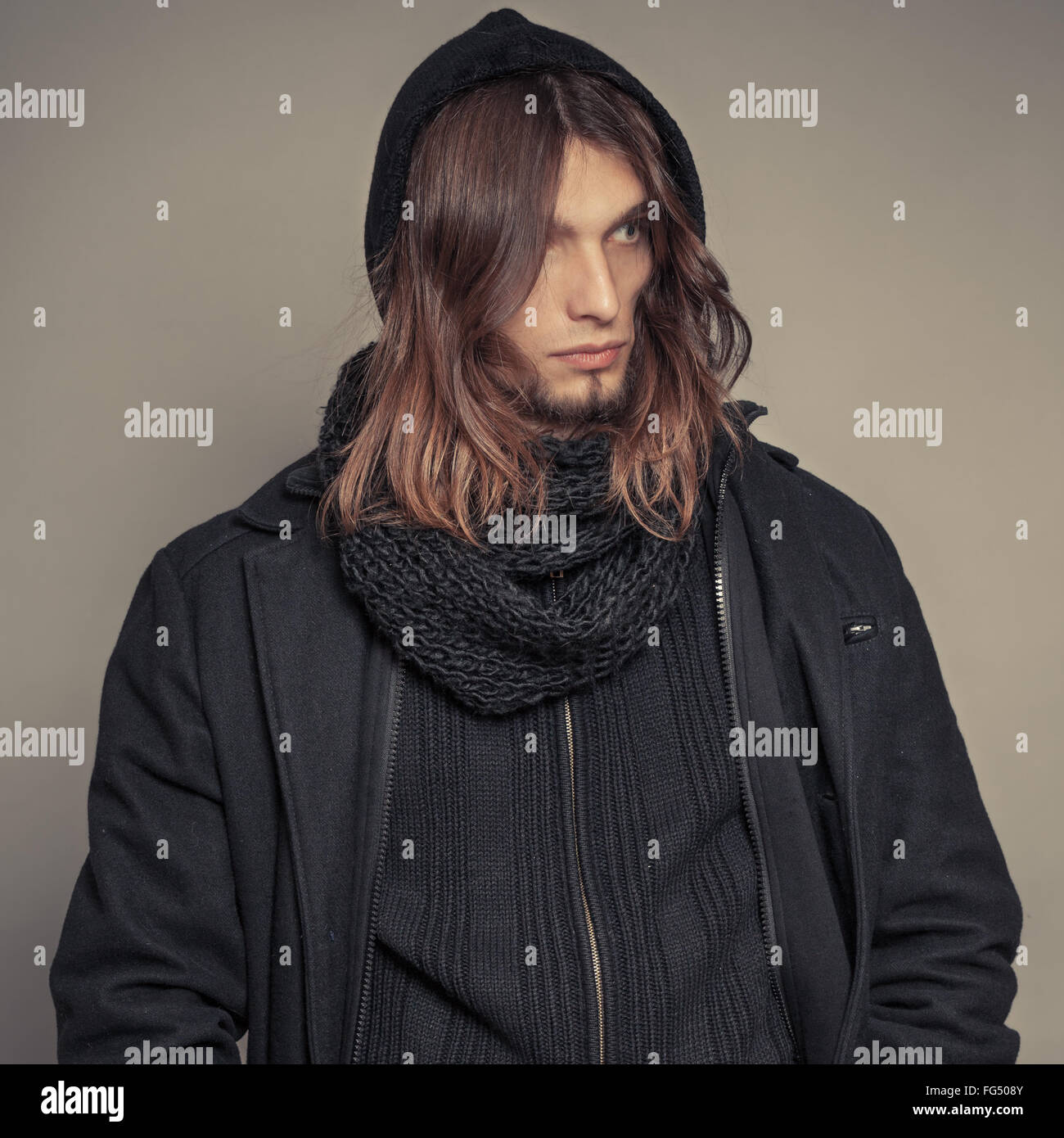 Portrait of handsome fashionable man wearing black coat and scarf ...