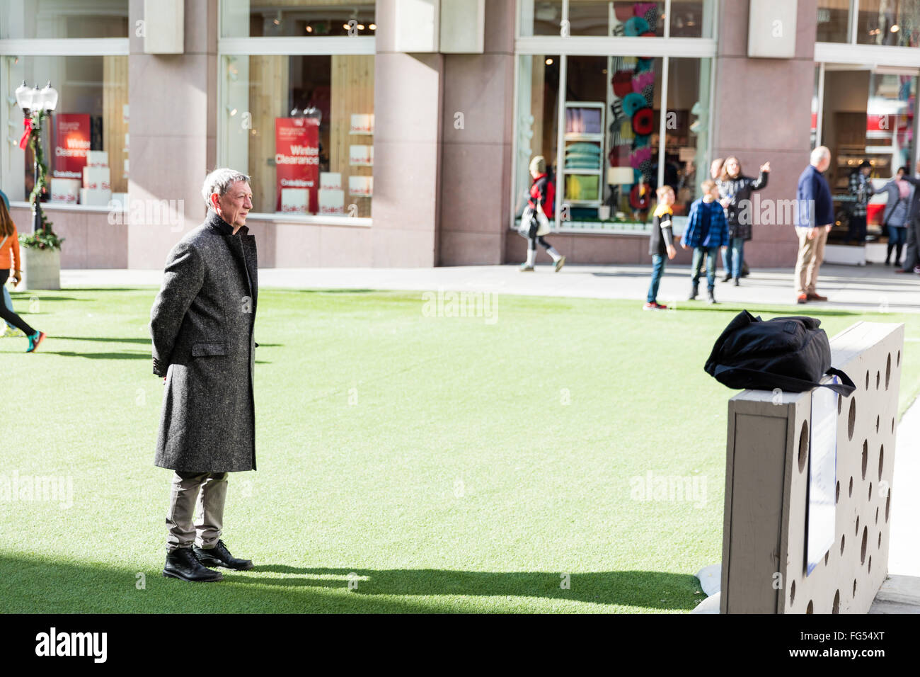 A man standing on a middle of the grass patch, warming up, Winter Walk SF, converted into a pedestrian plaza for the holidays Stock Photo