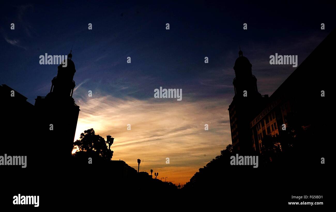 Low Angle View Of Silhouette Buildings Against Cloudy Sky During Sunrise Stock Photo