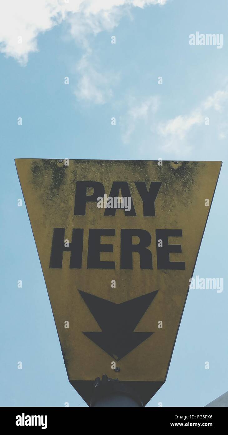 Low Angle View Of Pay Here Sign Against Sky Stock Photo