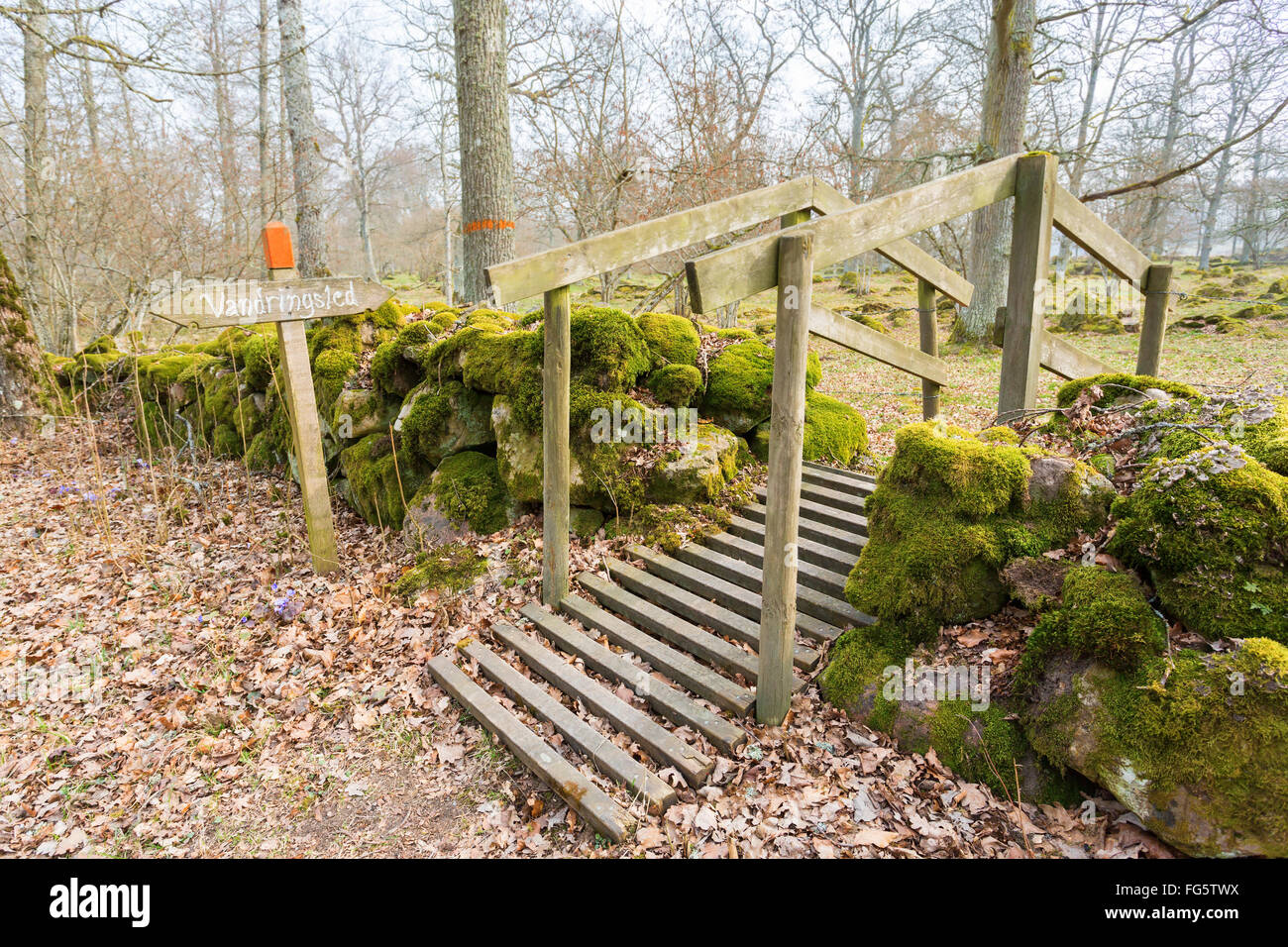 Footbridge over the stone wall on the footpath Stock Photo - Alamy