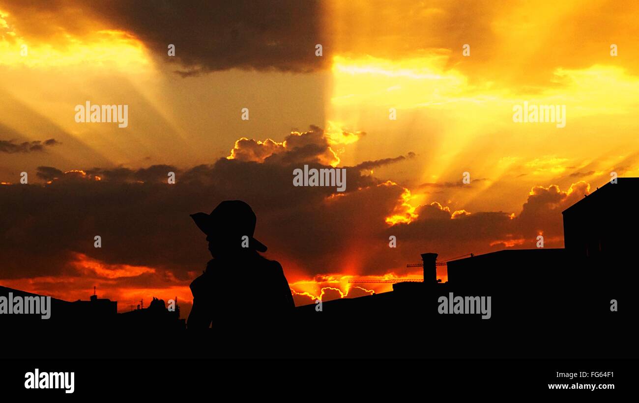 Silhouette Of Woman In Hat At Dusk Stock Photo