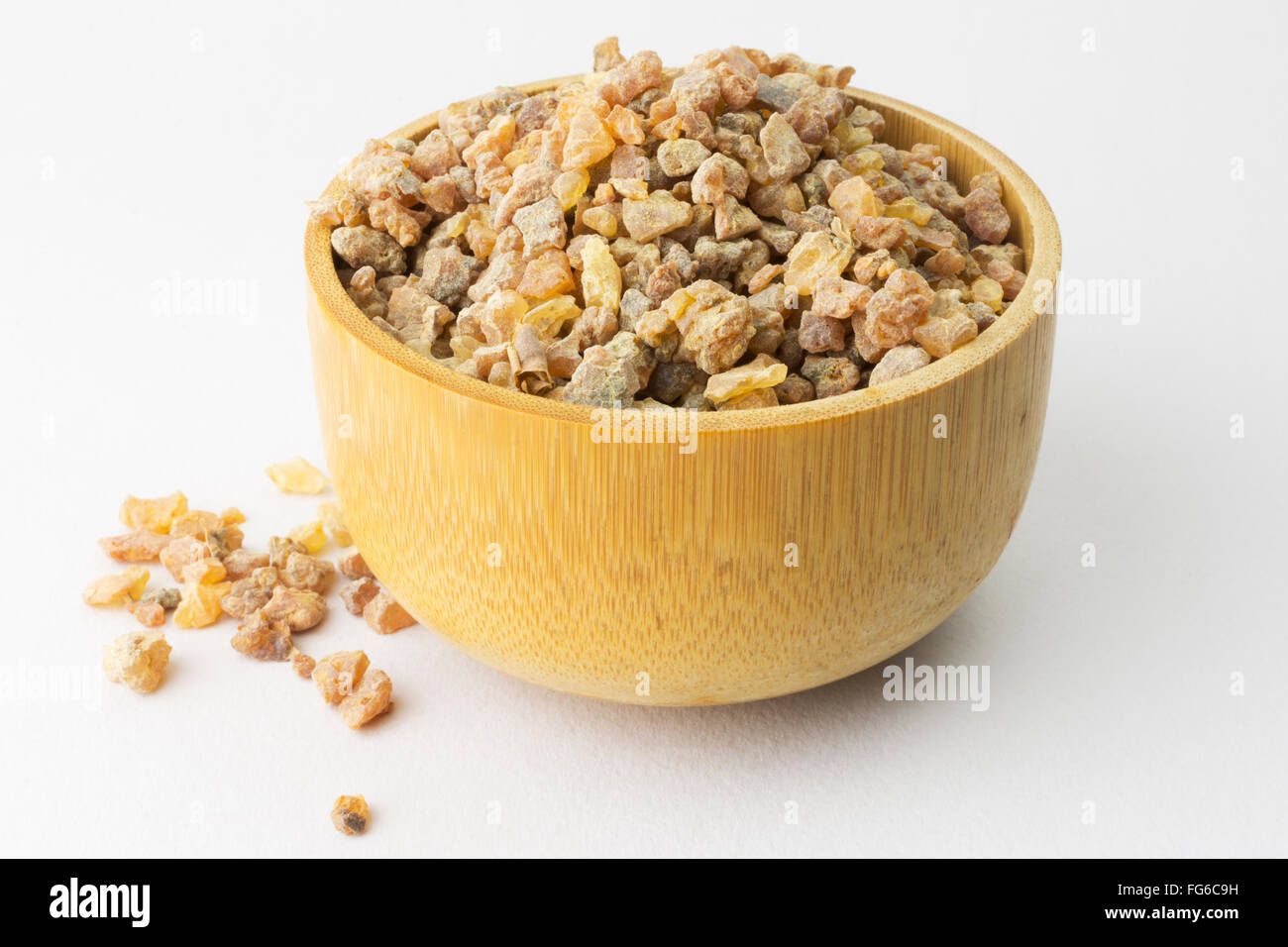 Pile of genuine Myrrh (Commiphora) resin grains in Wooden Bowl Stock Photo