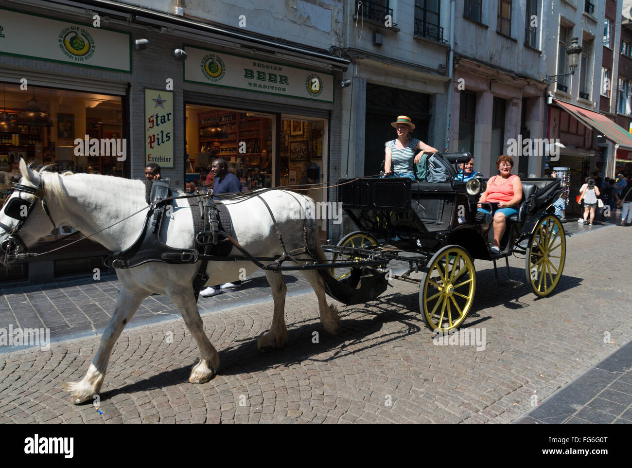 BRUSSELS, BELGIUM - JULY 11, 2015: Unknown tourists in a horse carriage in the center of Brussels Stock Photo