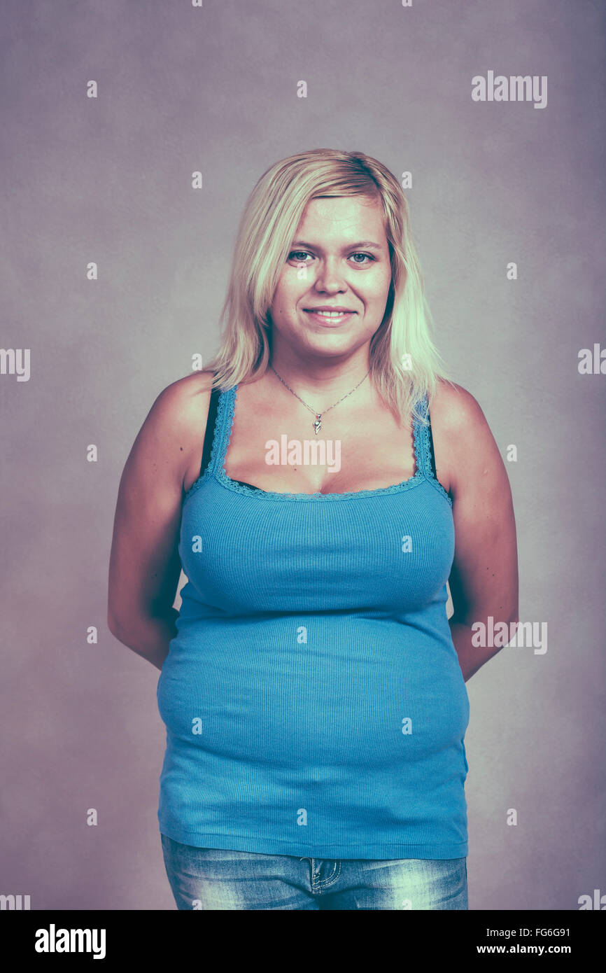 Portrait of a young chubby blond woman smiling. Stock Photo