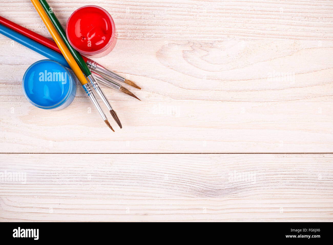 Blue red paints with various brushes on light wooden background Stock ...