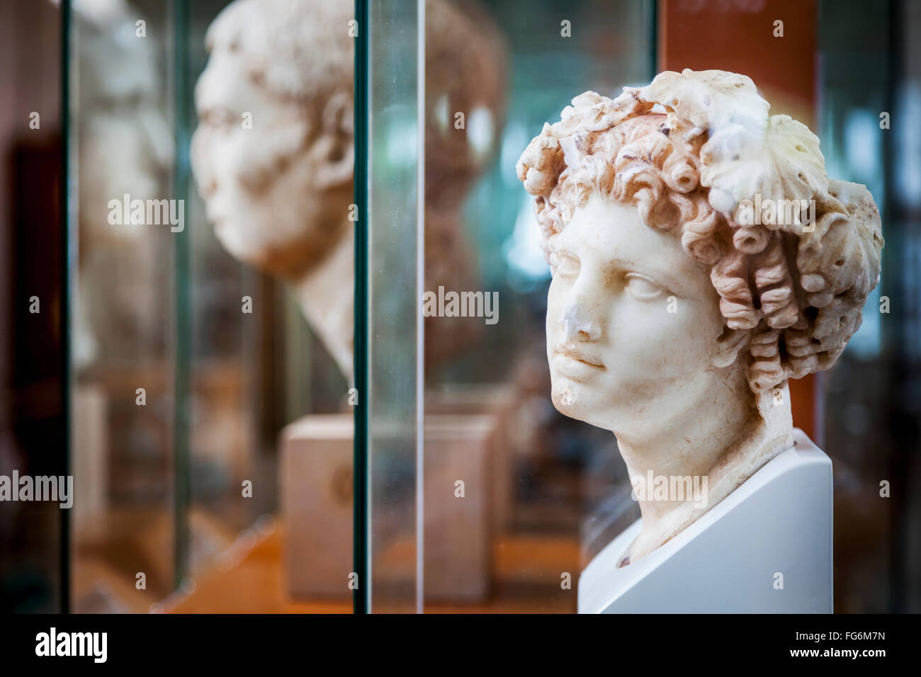 Sculpture of female head with curly hair at an archaeological museum
