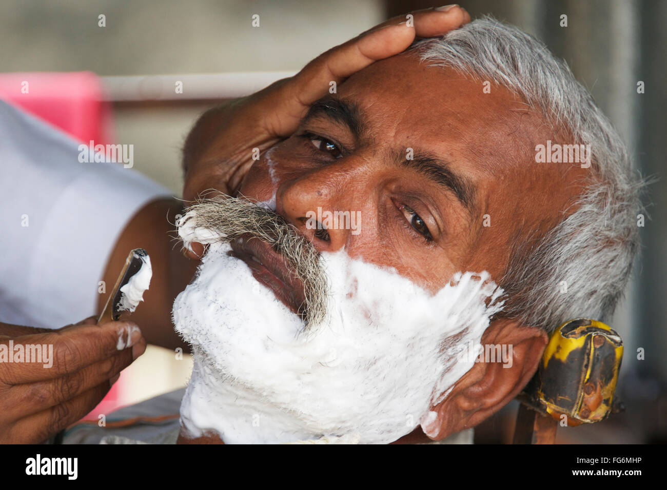 Face of Indian man being shaved; Dharpatha Mal, Madhya Pradesh, India Stock Photo