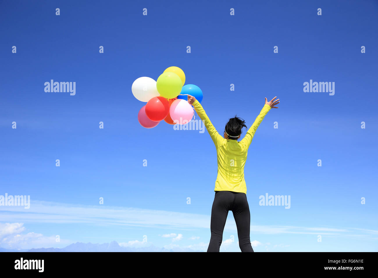 young cheering woman with colorful balloons on mountain peak Stock ...