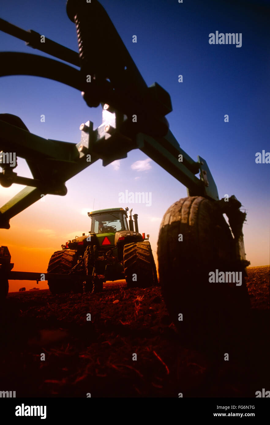 Agriculture - Low angle view of a John Deere tracked tractor and air till drill no-till drilling (planting) canola in spring / Manitoba, Canada. Stock Photo