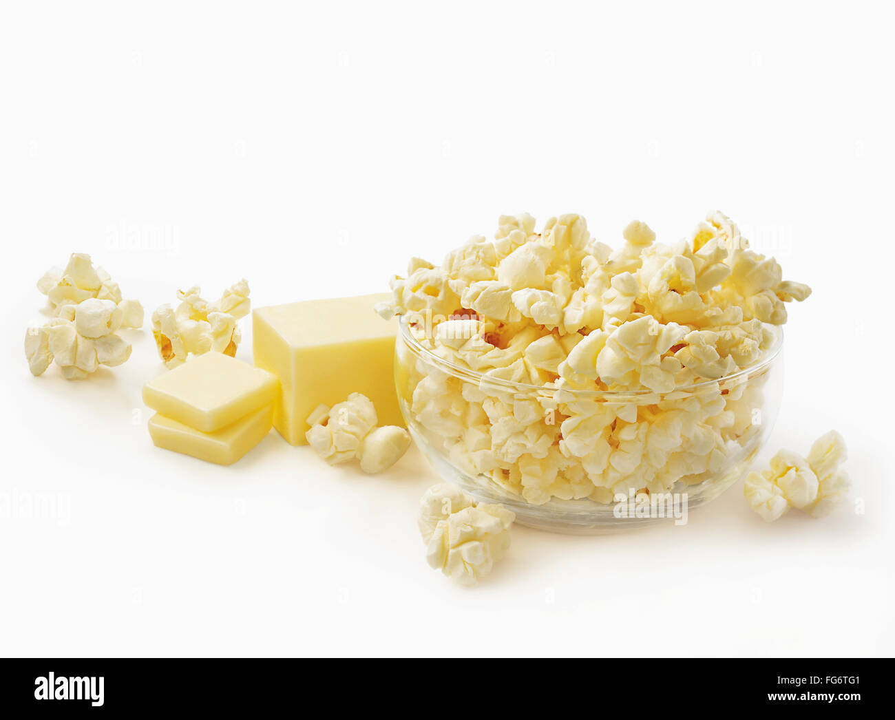 Bowl of popcorn with block of cut butter on a white background; Toronto