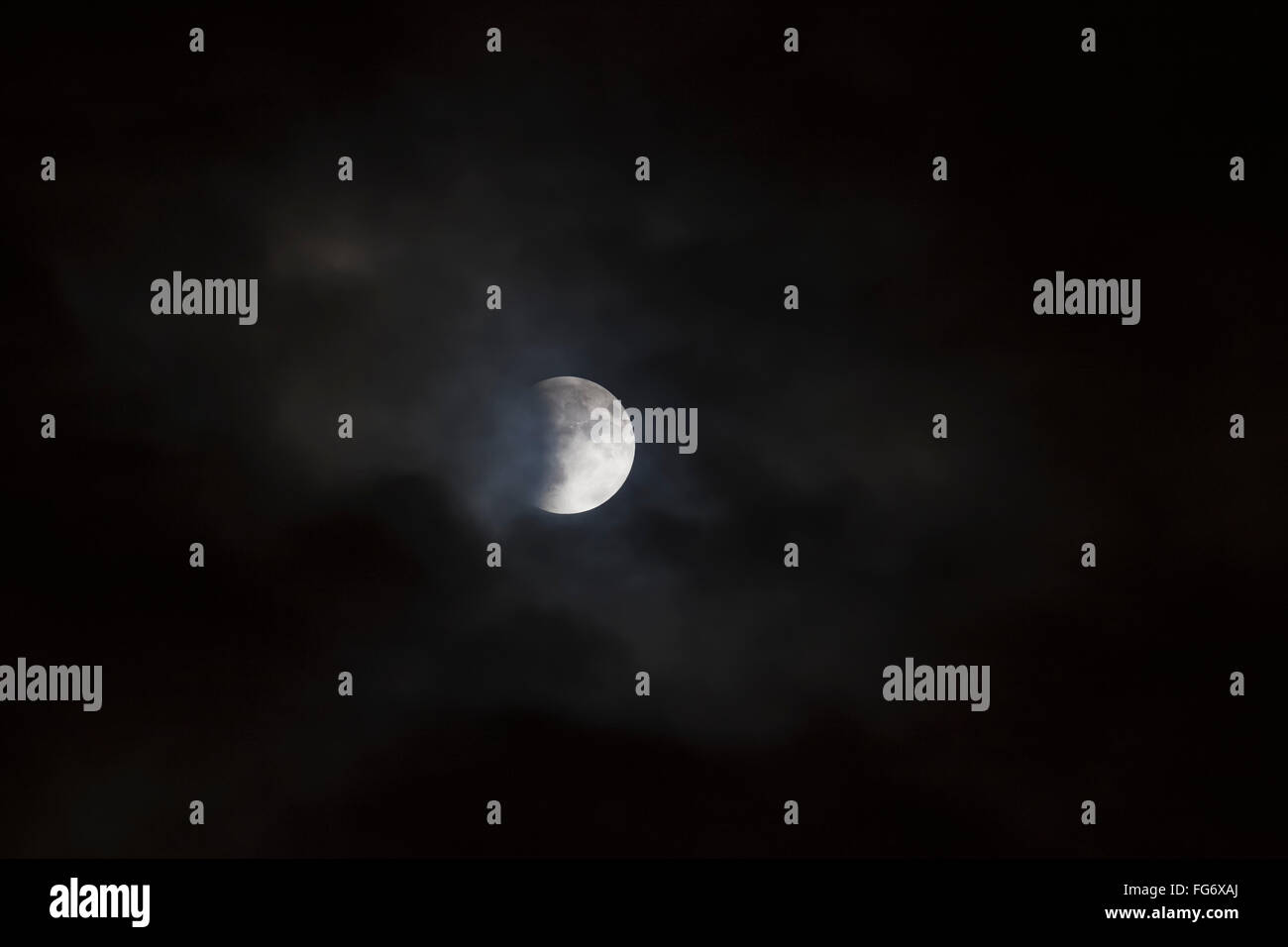 Lunar eclipse, viewed through passing clouds; Brampton, Ontario, Canada