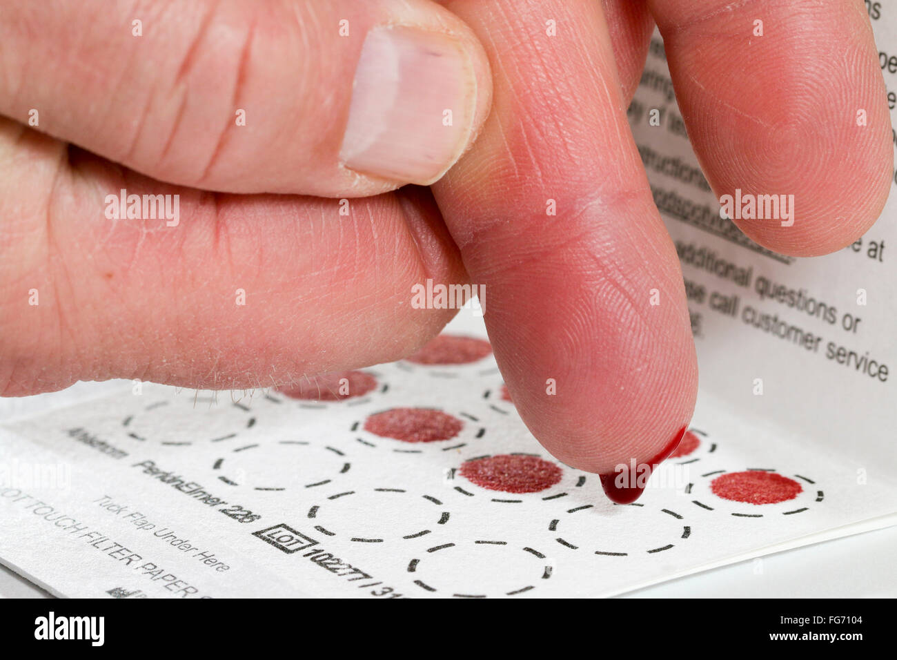 Home blood test. Depositing blood on filter paper. Stock Photo