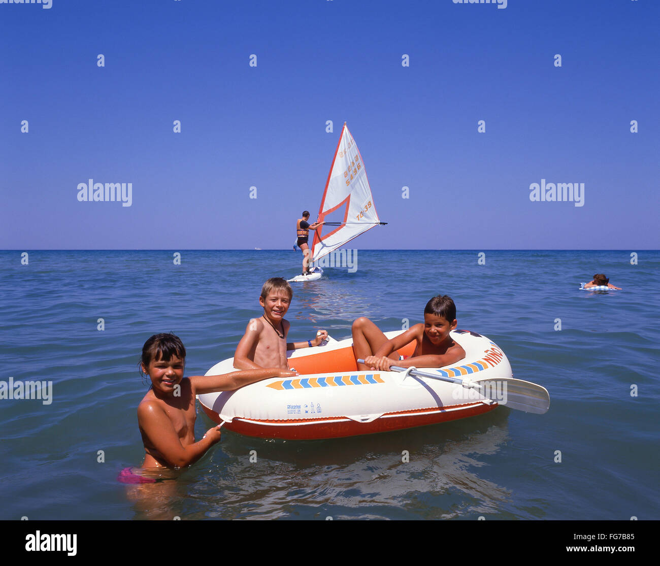 Children playing on inflatable dingy, Positano, Amalfi Coast, Province of Salerno, Campania Region, Italy Stock Photo