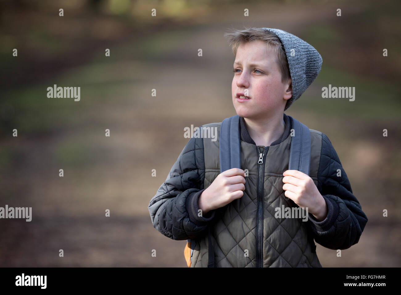 A boy with a rucksack walking in the woods Stock Photo
