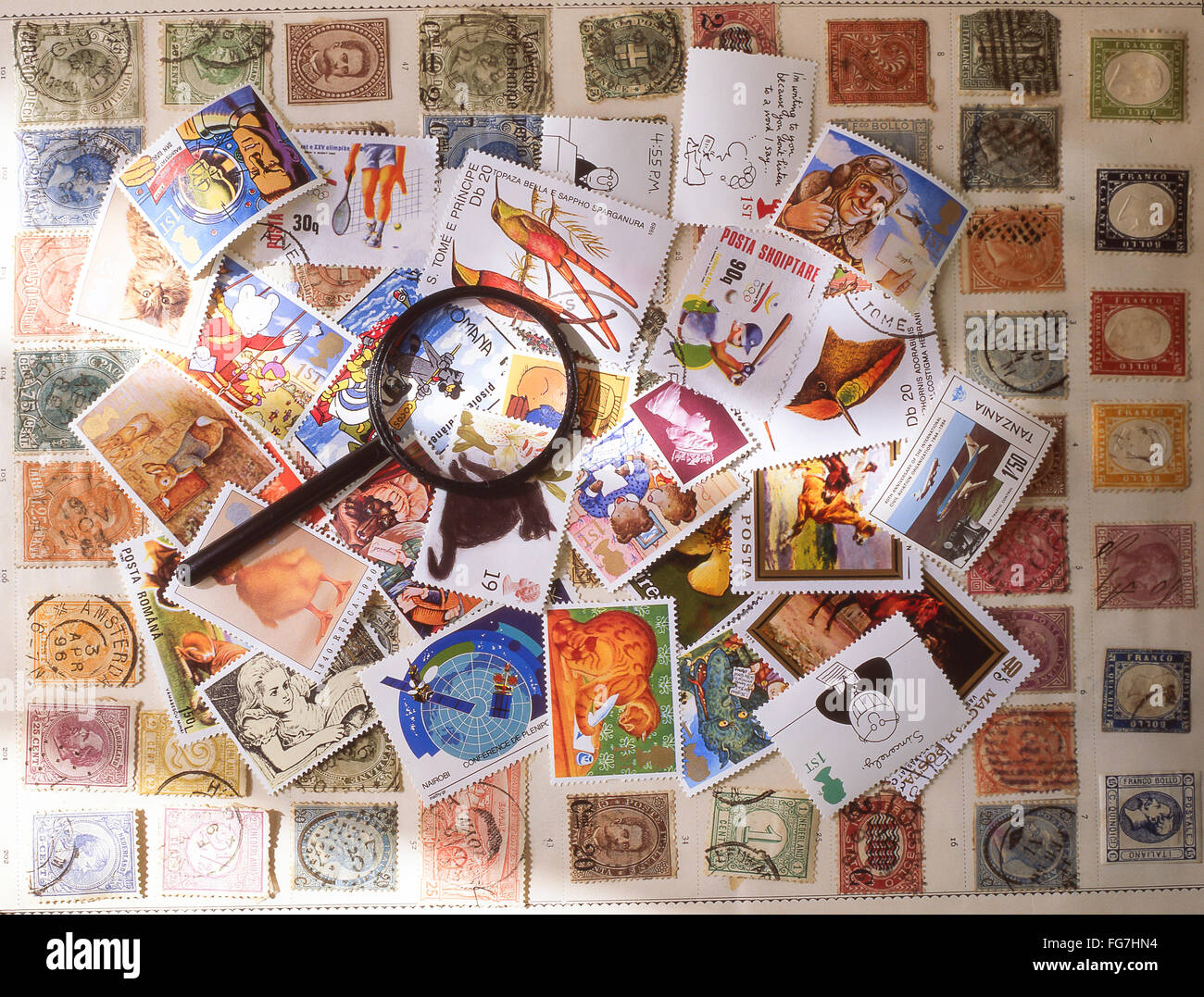 Collection of stamps with magnifying glass in studio setting, Berkshire, England, United Kingdom Stock Photo