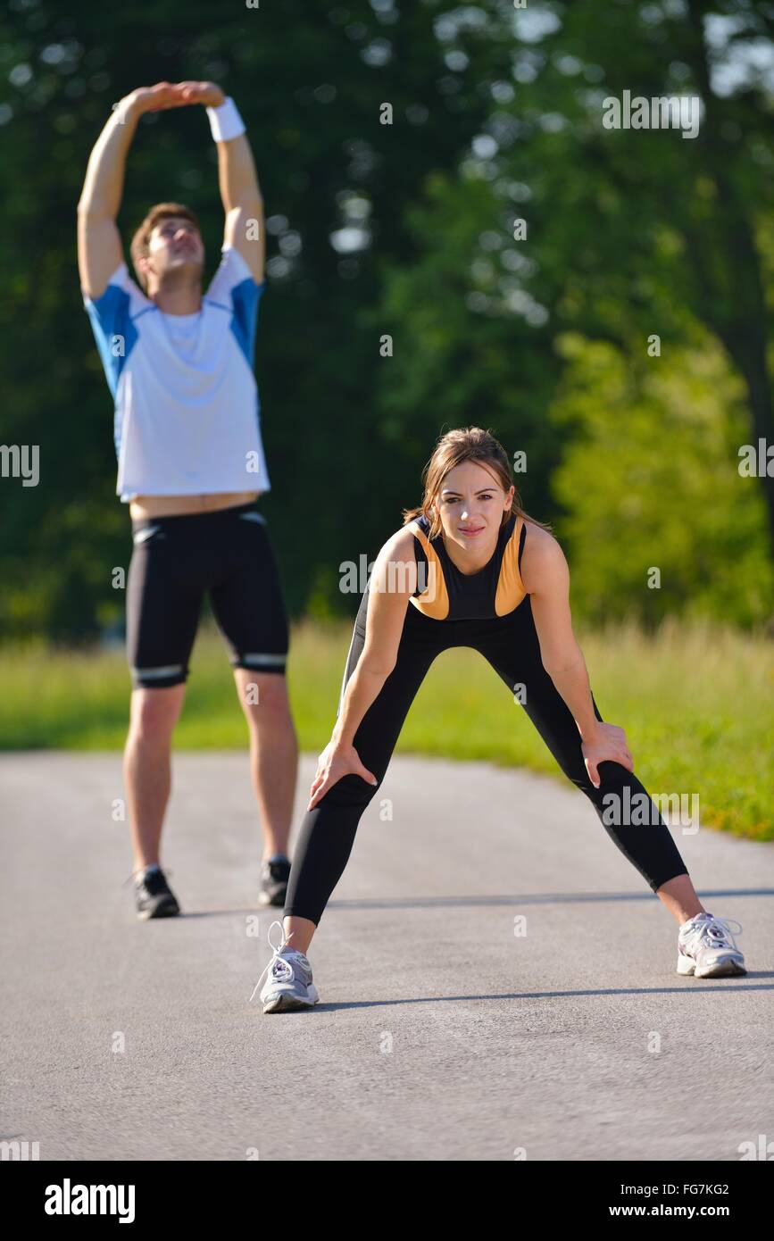 Couple doing stretching exercise after jogging Stock Photo - Alamy