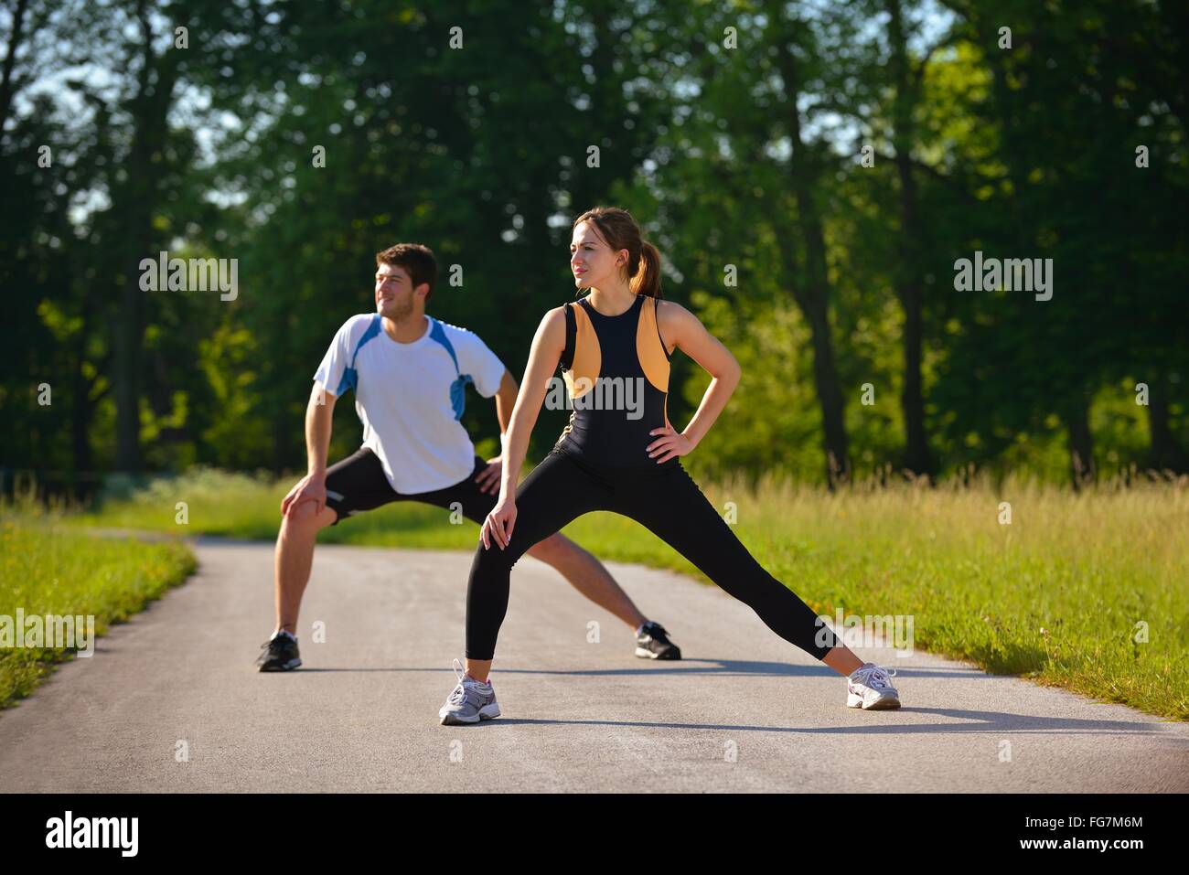Couple doing stretching exercise after jogging Stock Photo - Alamy