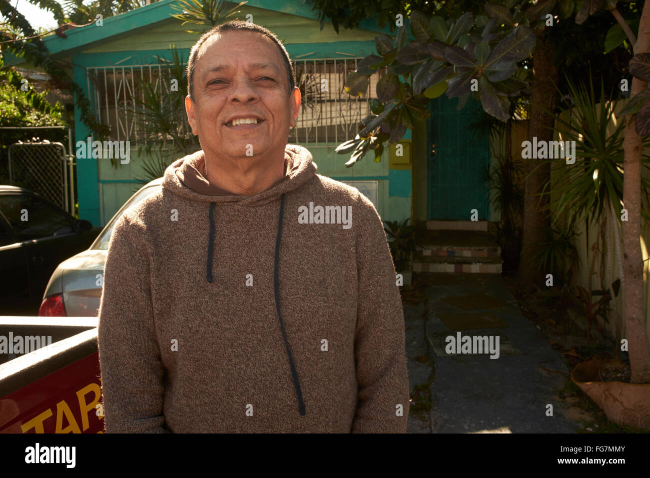 hispanic american stands in front of his modest house in Miami, Florida Stock Photo