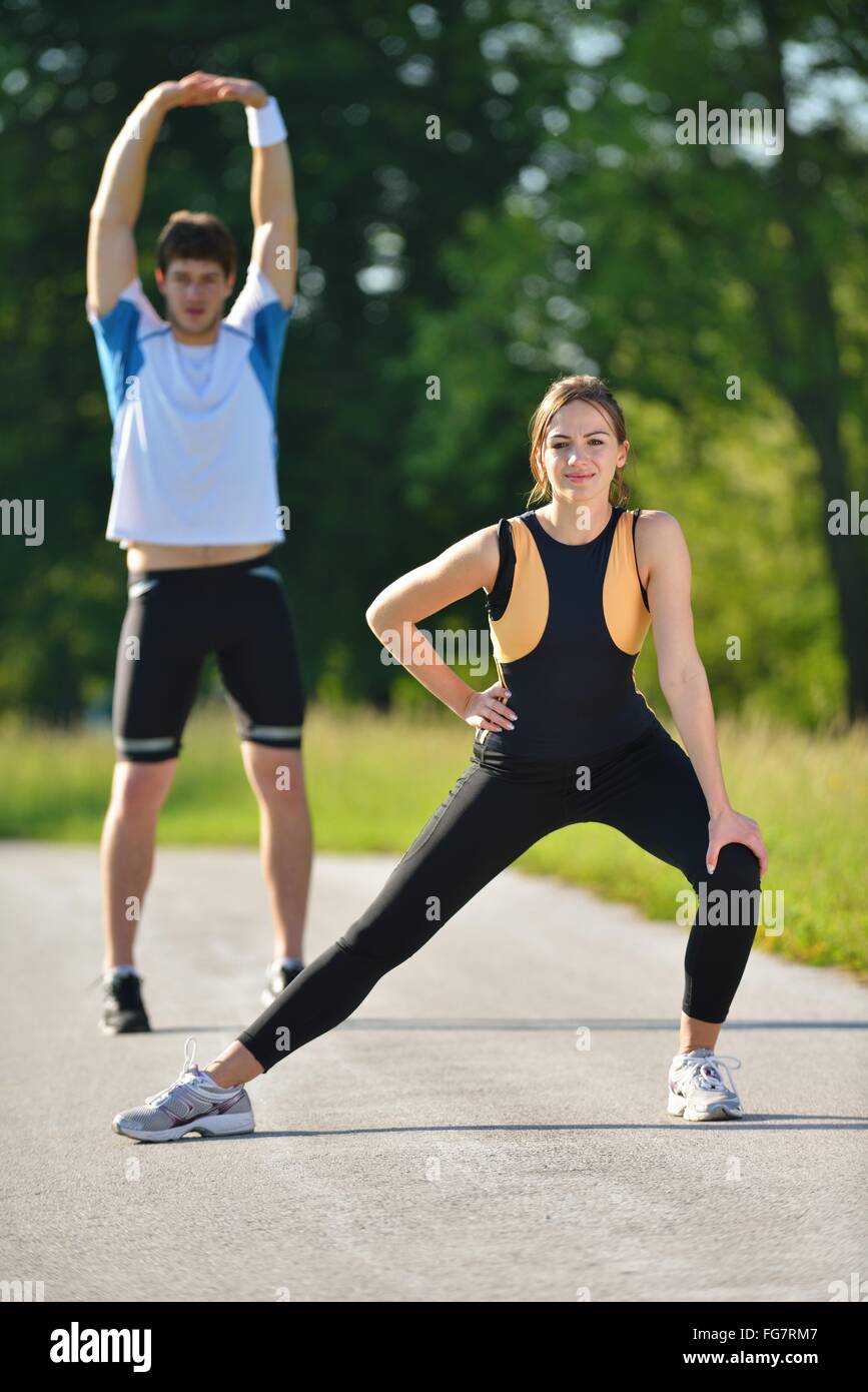 Couple doing stretching exercise after jogging Stock Photo - Alamy
