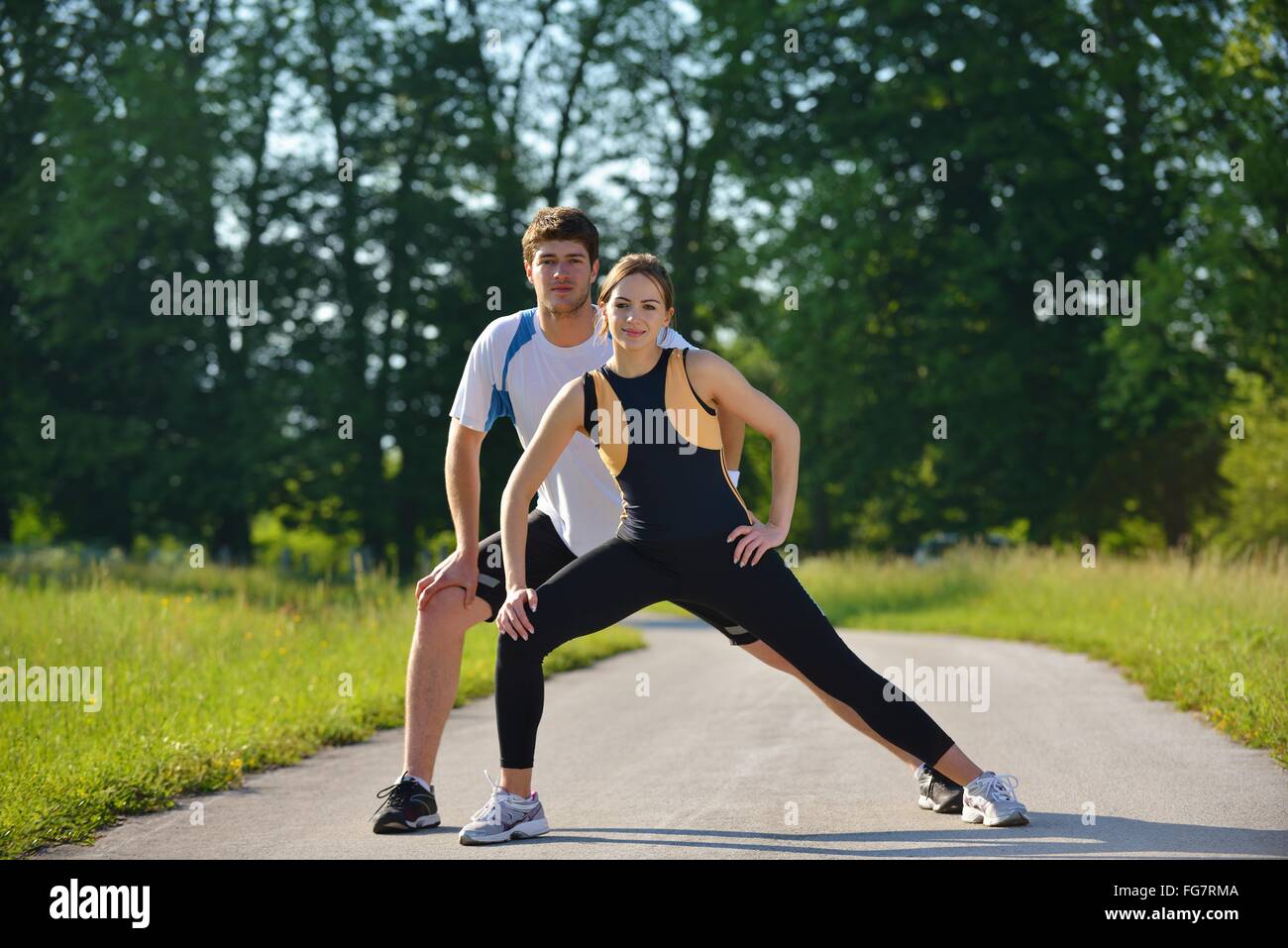 Couple doing stretching exercise after jogging Stock Photo - Alamy