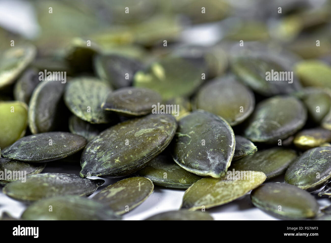 Close up of pumpkin seeds on white background Stock Photo