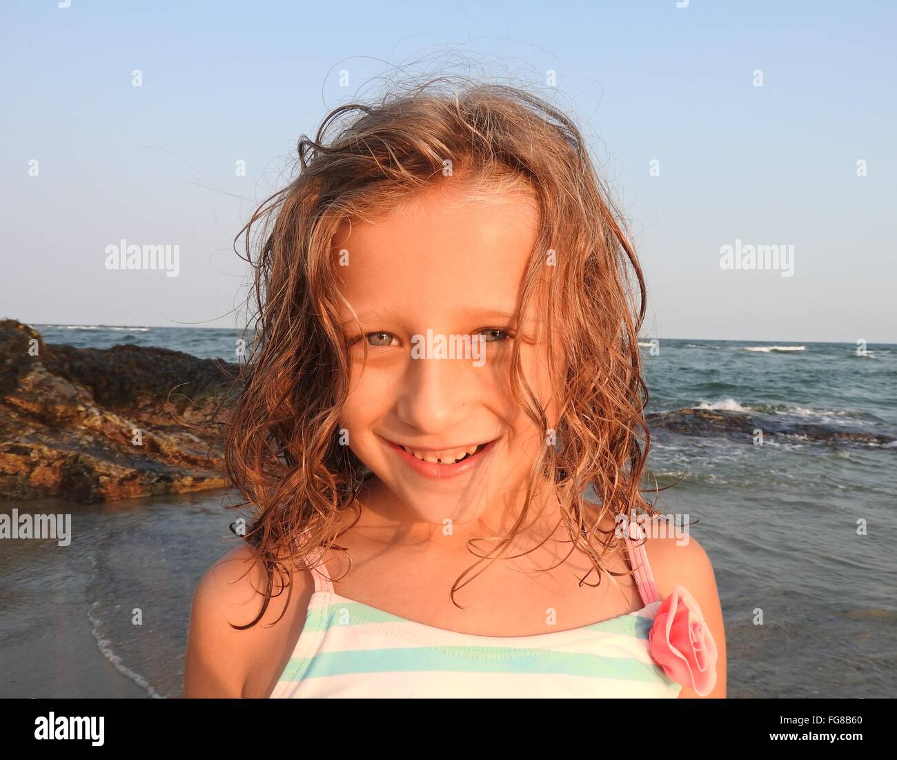 Portrait Of Smiling Girl Standing On Beach Stock Photo - Alamy