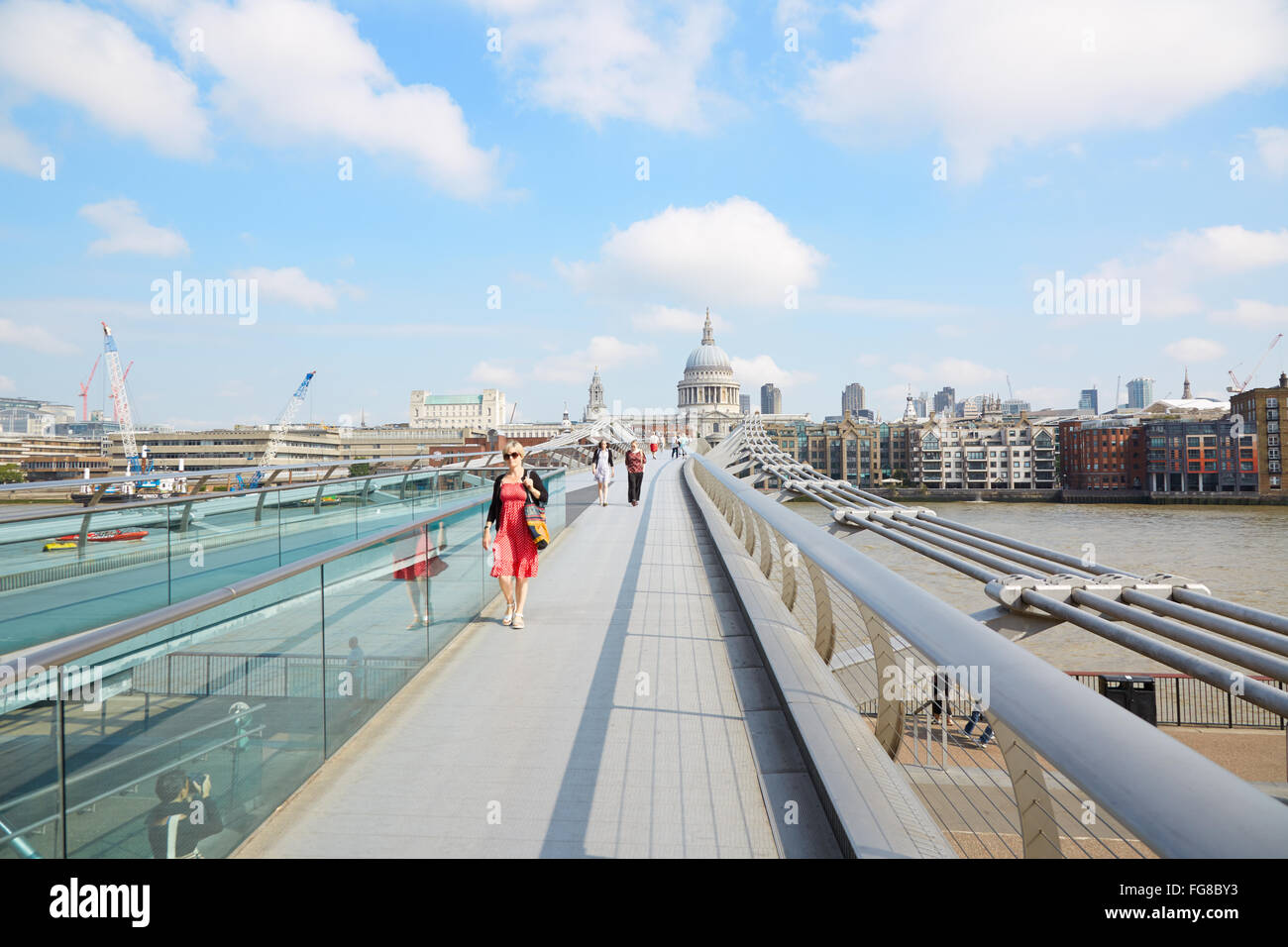 Millennium bridge with people walking and St Paul cathedral in a sunny morning in London Stock Photo