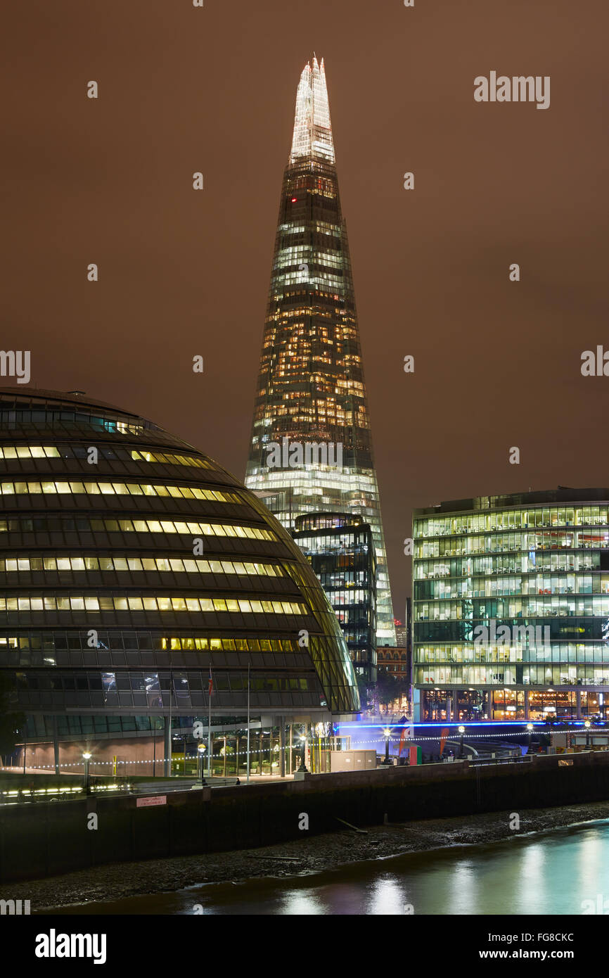 The Shard building illuminated, City Hall and Thames river at night in London Stock Photo