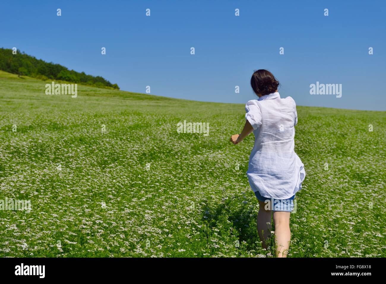 Young happy woman in green field Stock Photo - Alamy