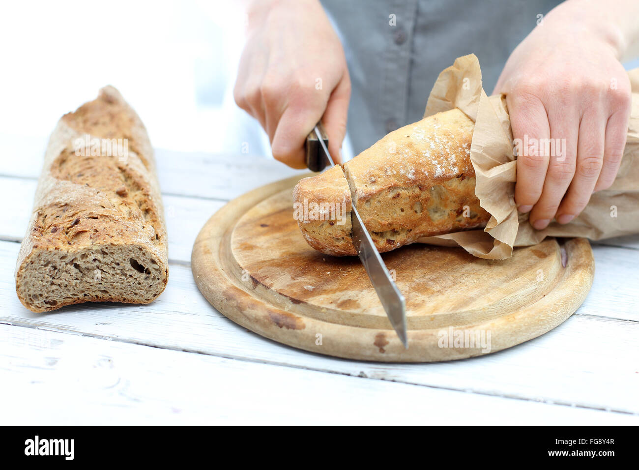 https://c8.alamy.com/comp/FG8Y4R/woman-hands-cutting-bread-on-the-kitchen-counter-baguette-slicing-FG8Y4R.jpg