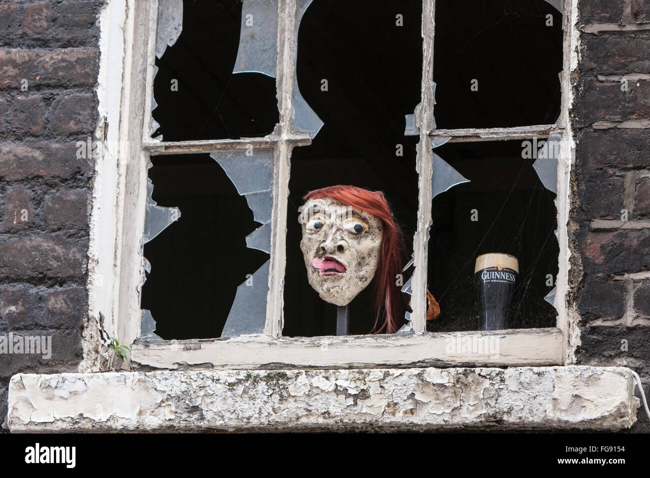 Broken window opposite old Guinness Storehouse with pint of Guinness,and,funny,face,Irish,humour,humour, ,Dublin,Ireland. Stock Photo