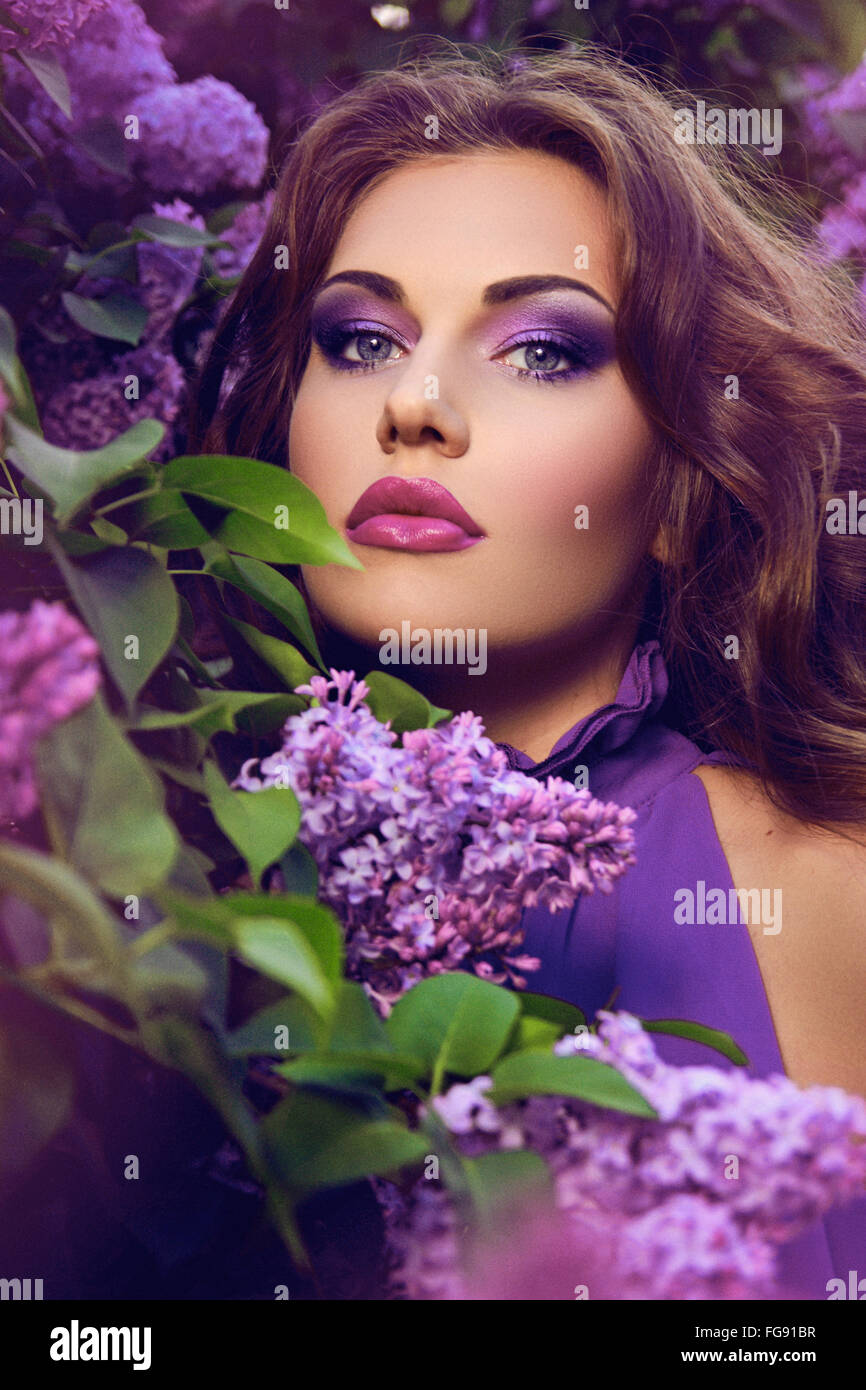 The girl's face. Beautiful girl with flowers. Lilac. Blue dress. Stock Photo