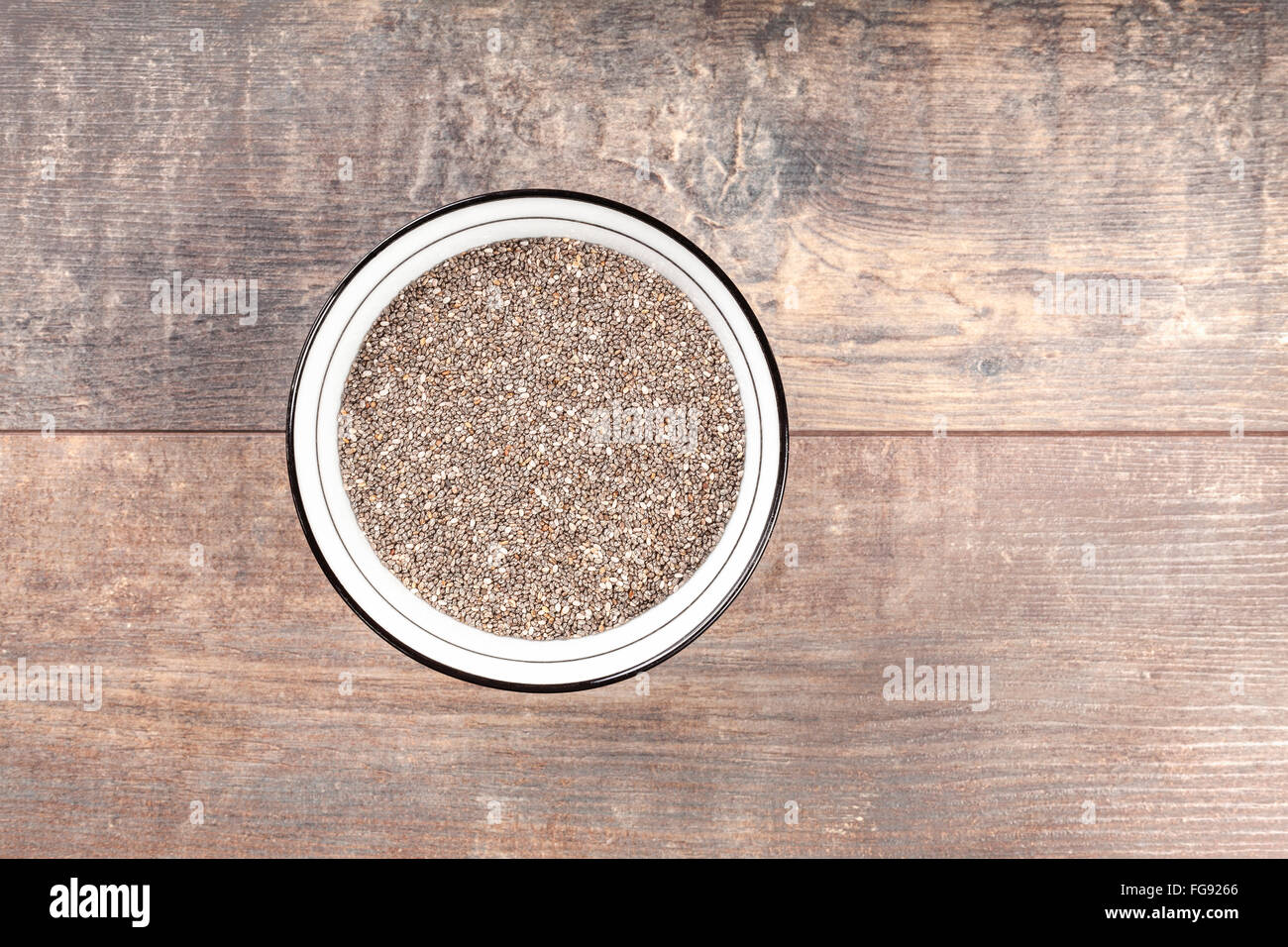 Chia seeds in a bowl on wooden background. Stock Photo