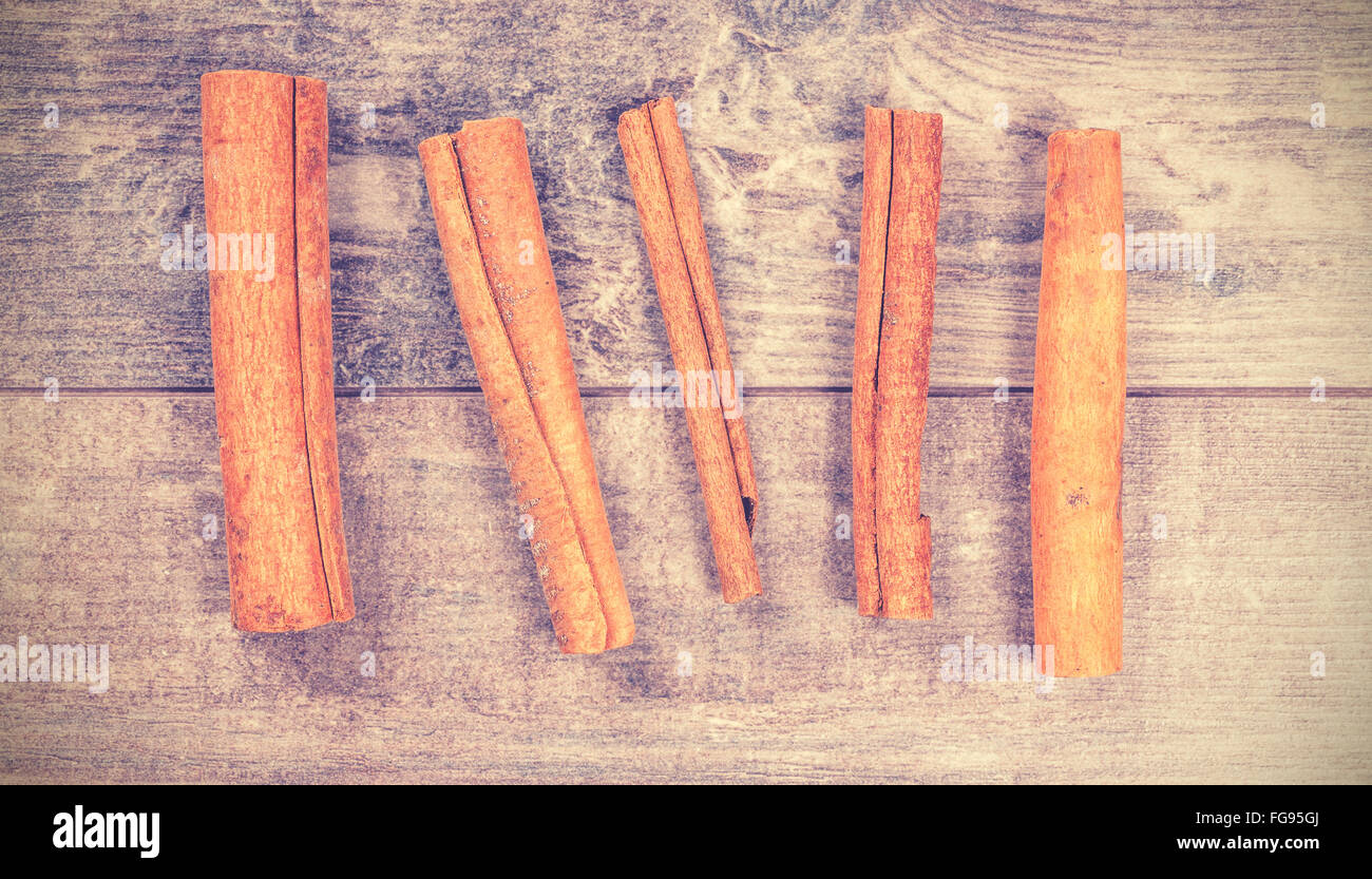 Vintage stylized cinnamon sticks on wooden background. Stock Photo
