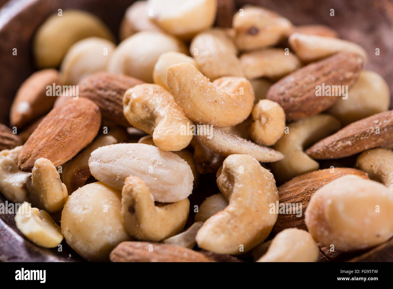 Portion of mixed nuts (roasted and salted) on an old wooden table