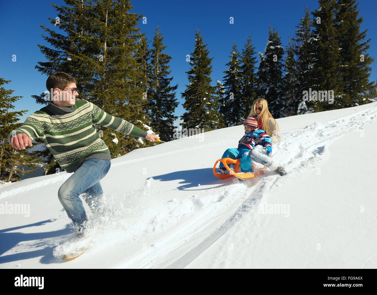 family having fun on fresh snow at winter Stock Photo