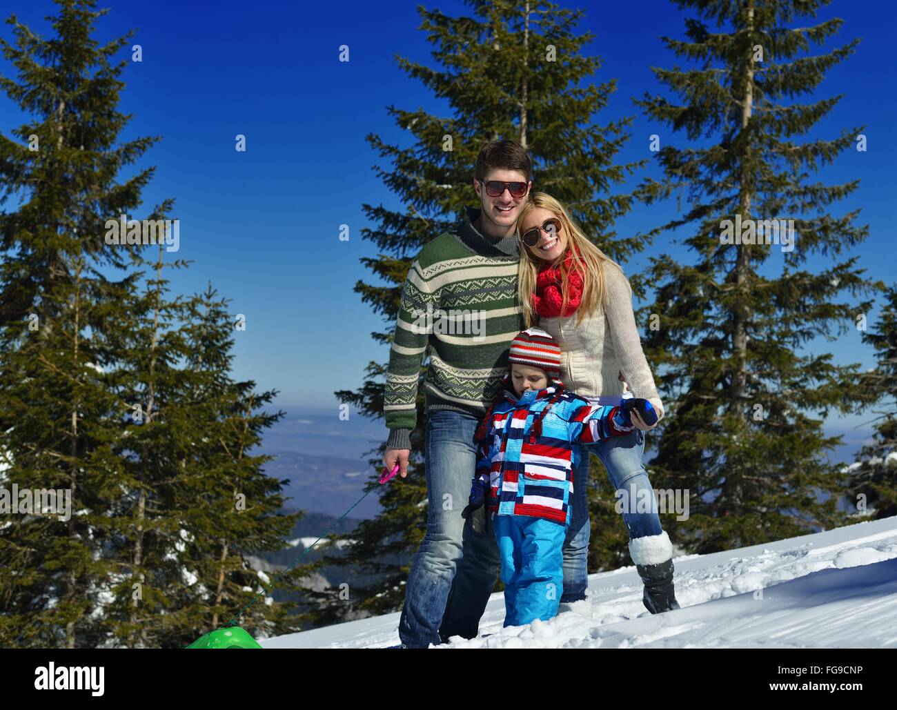 family having fun on fresh snow at winter vacation Stock Photo