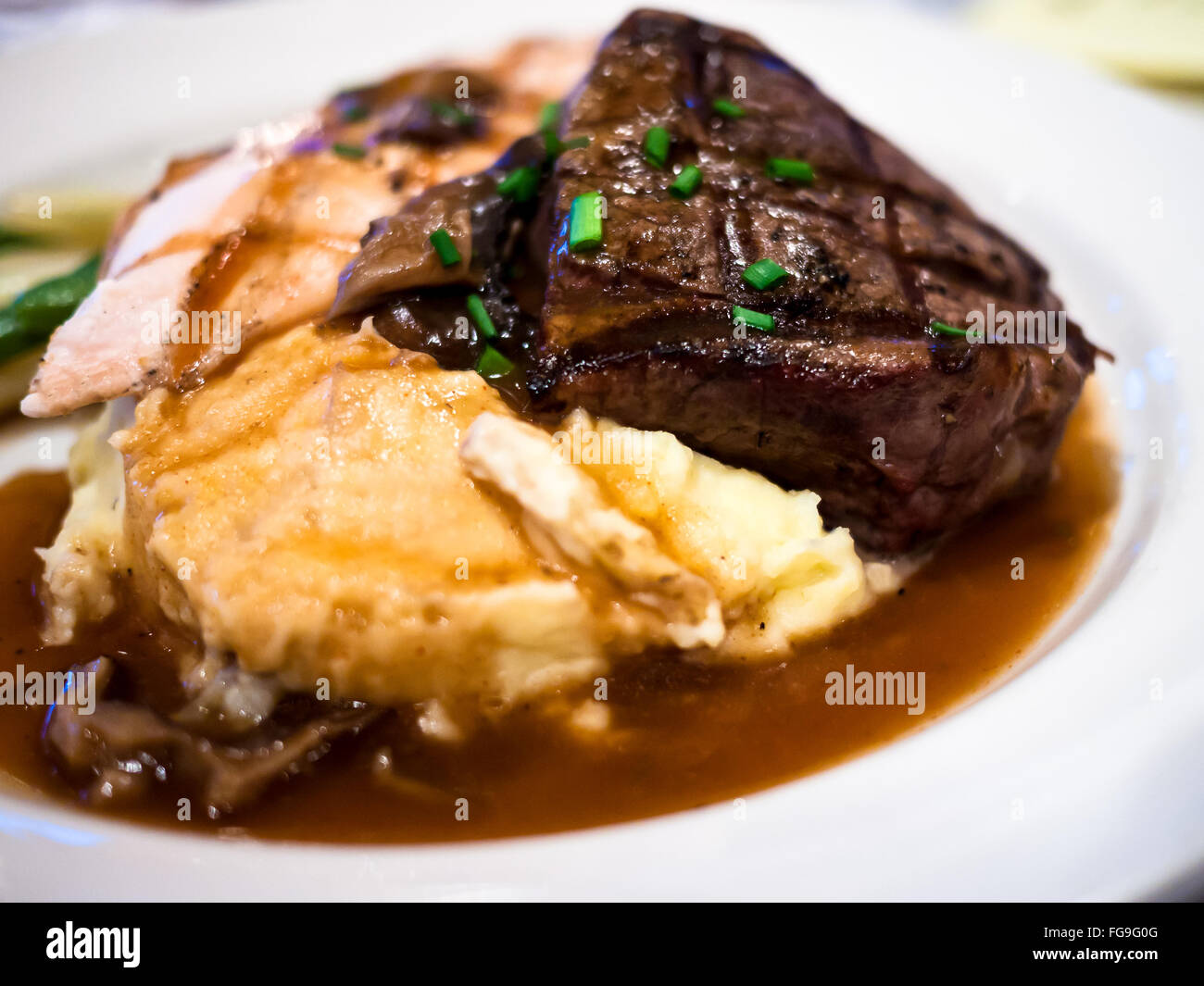 Steak, potatoes, and gravy on a white plate Stock Photo