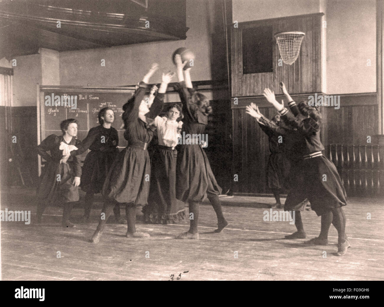 Female students playing basketball in a gymnasium     Western High School     Washington DC  - 1899 Stock Photo