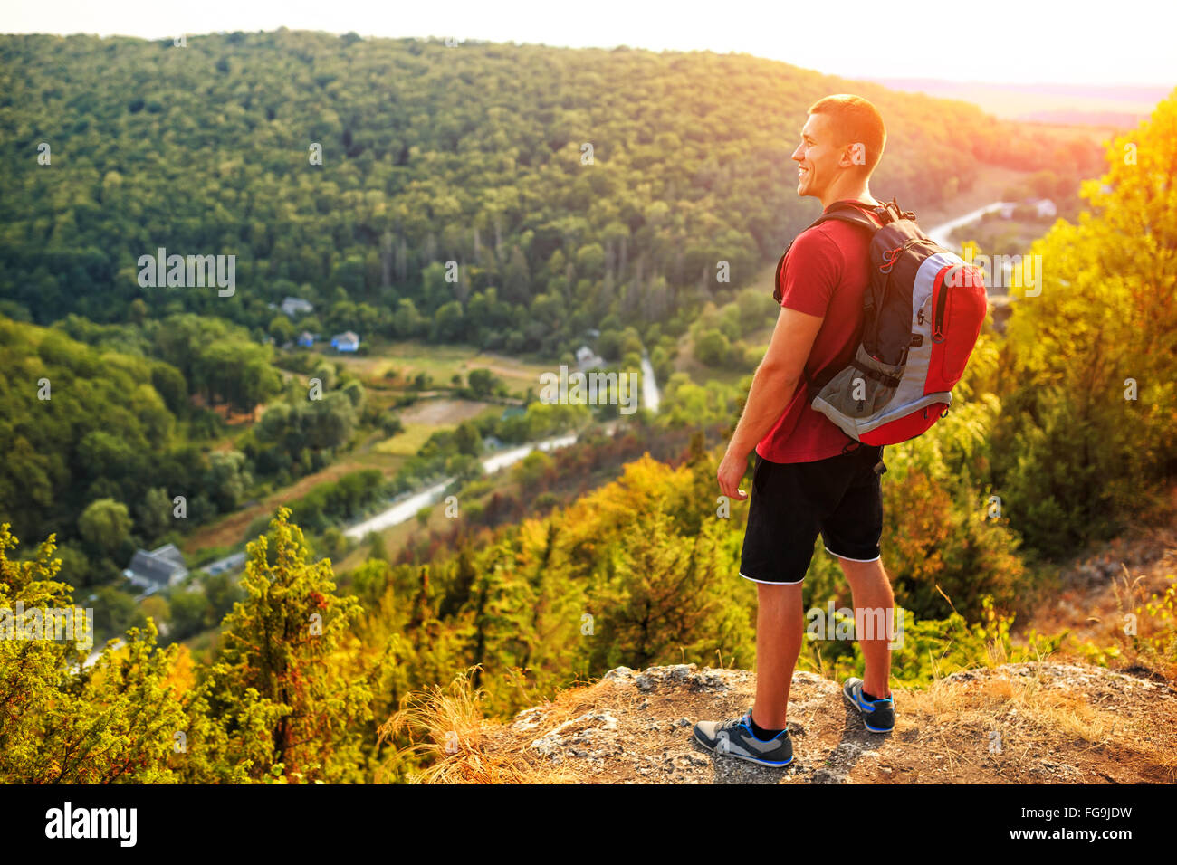 Hiker with backpack standing on top of a mountain Stock Photo - Alamy