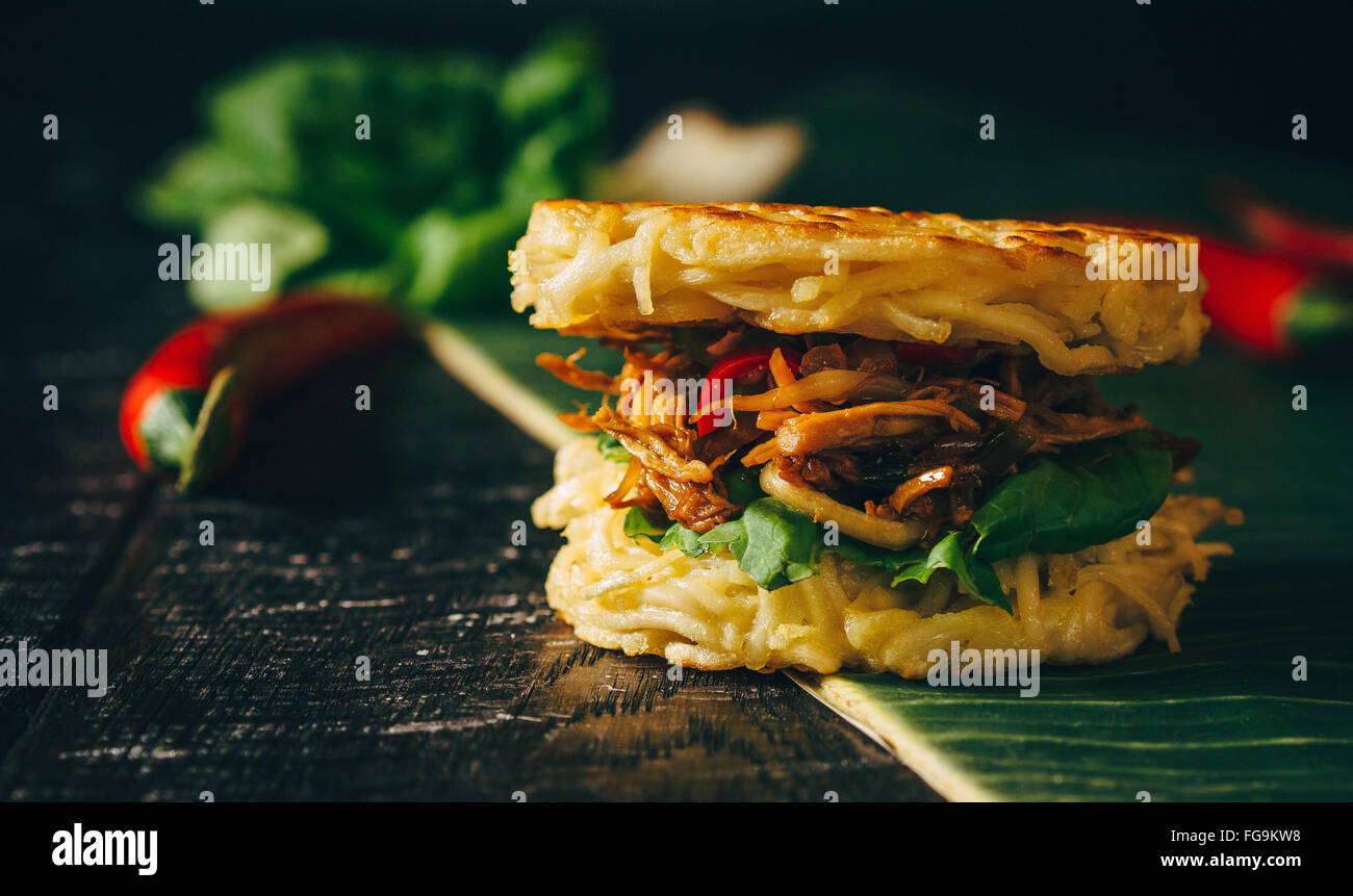 Close-Up Of Ramen Burger With Chicken On Banana Leaf Stock Photo