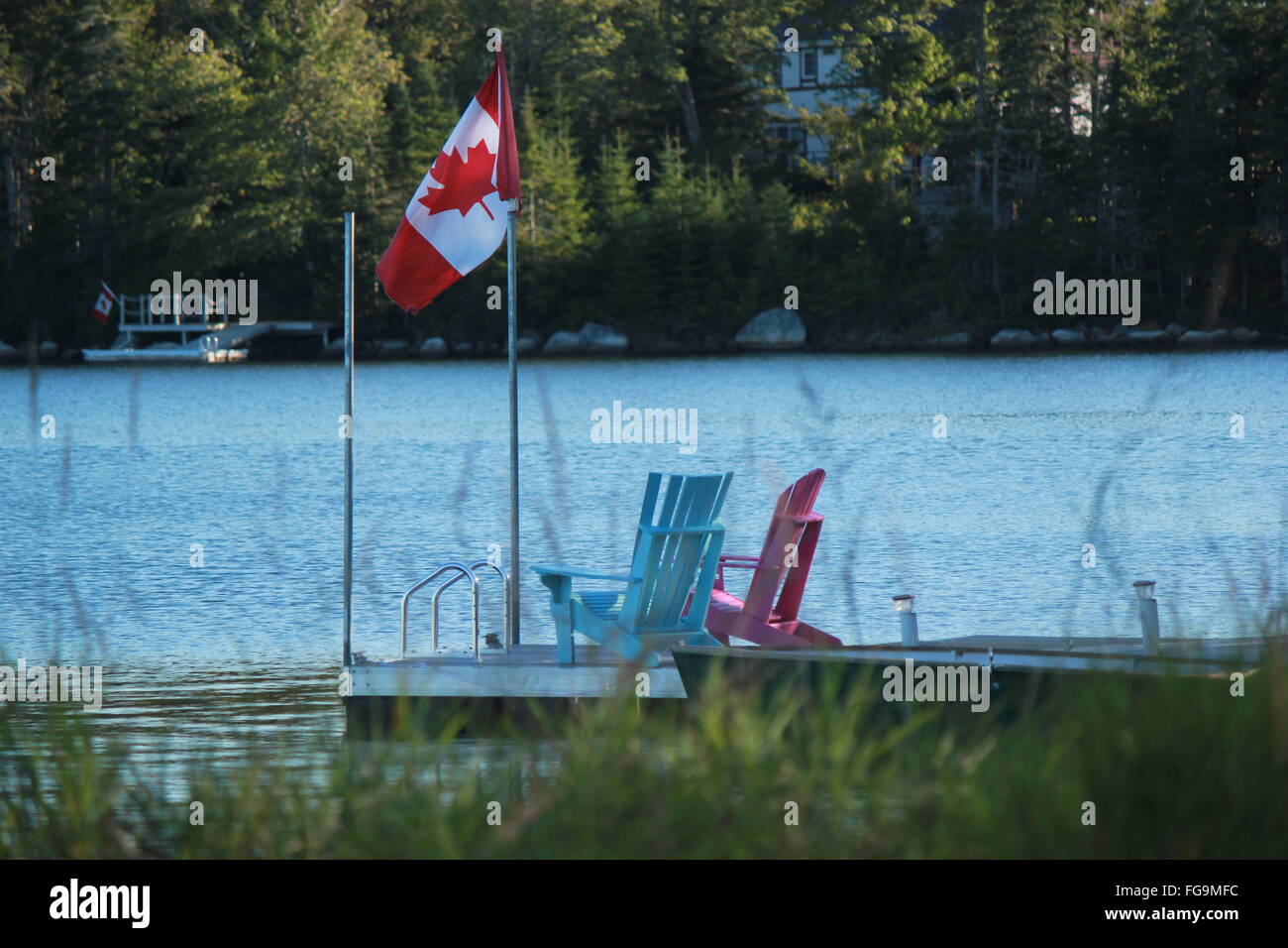 Canadian Flag On Jetty With Adirondack Chairs In Lake Stock Photo Alamy